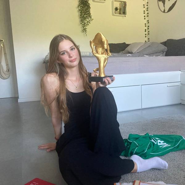 Zu sehen ist die Poetry-Slammerin Hannah Breitbarth mit einem Pokal in der Hand.