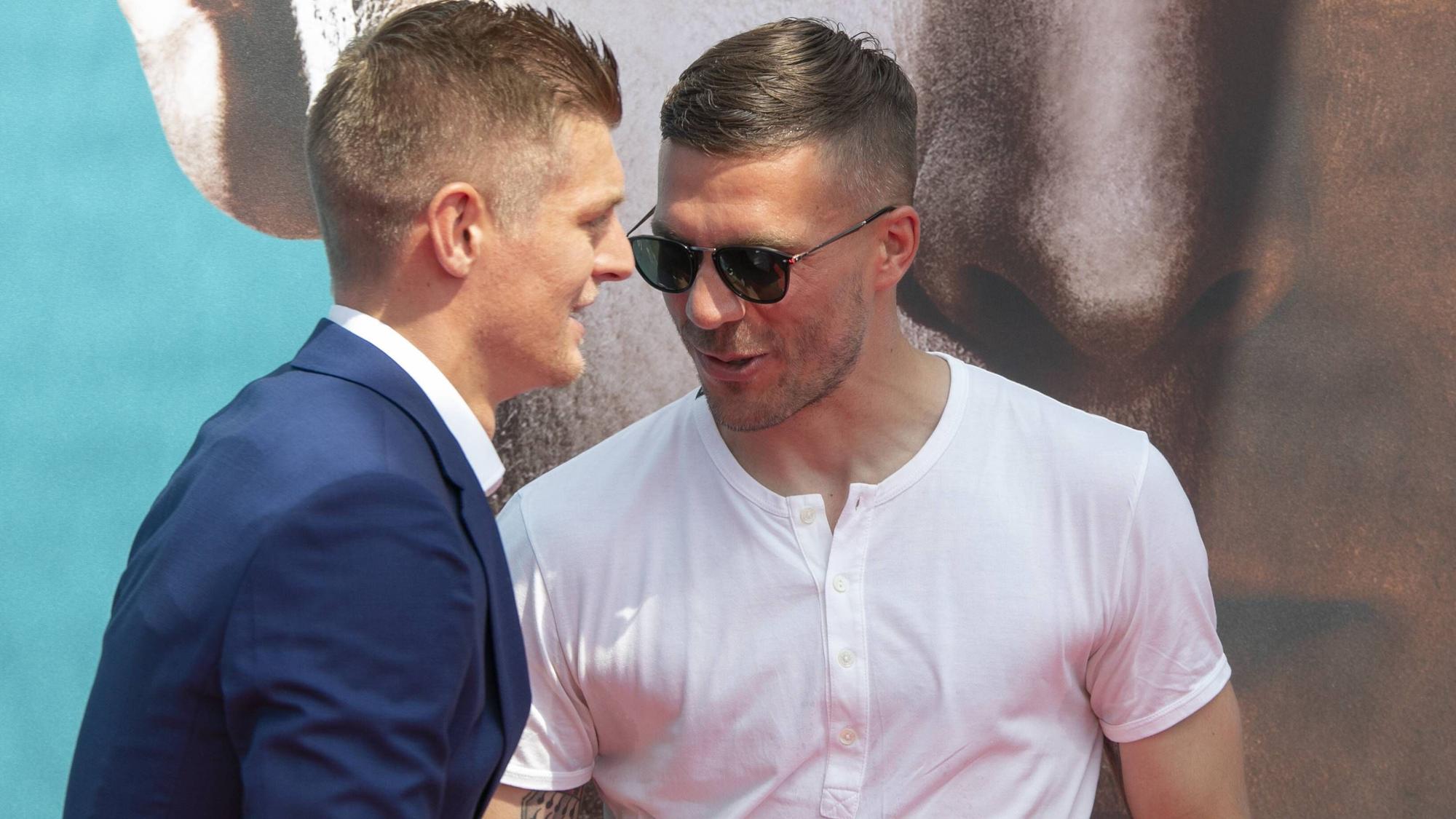 Lukas Podolski (r.) und Toni Kroos begrüßen sich.