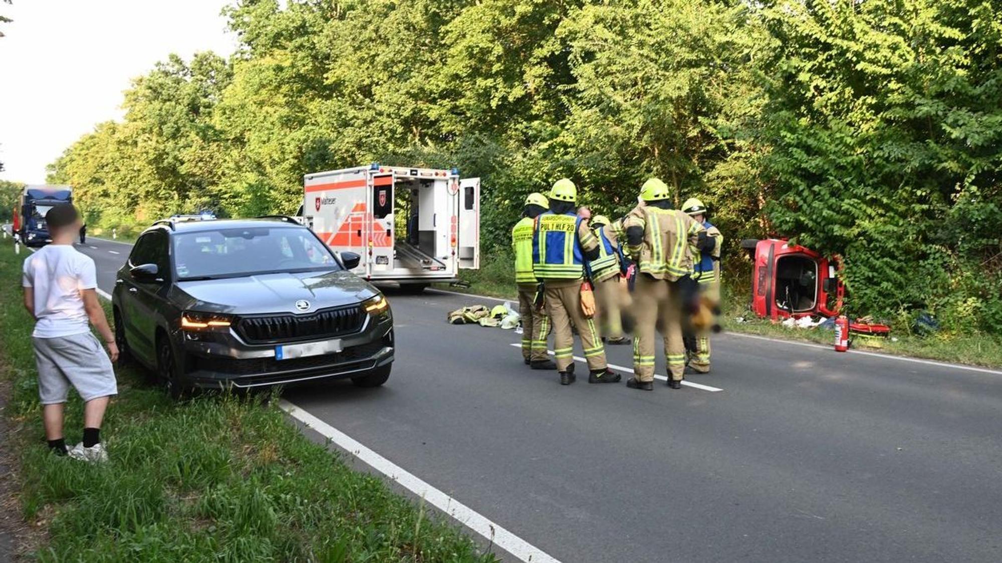 Ein Kleinwagen liegt auf der Seite im Straßengraben.