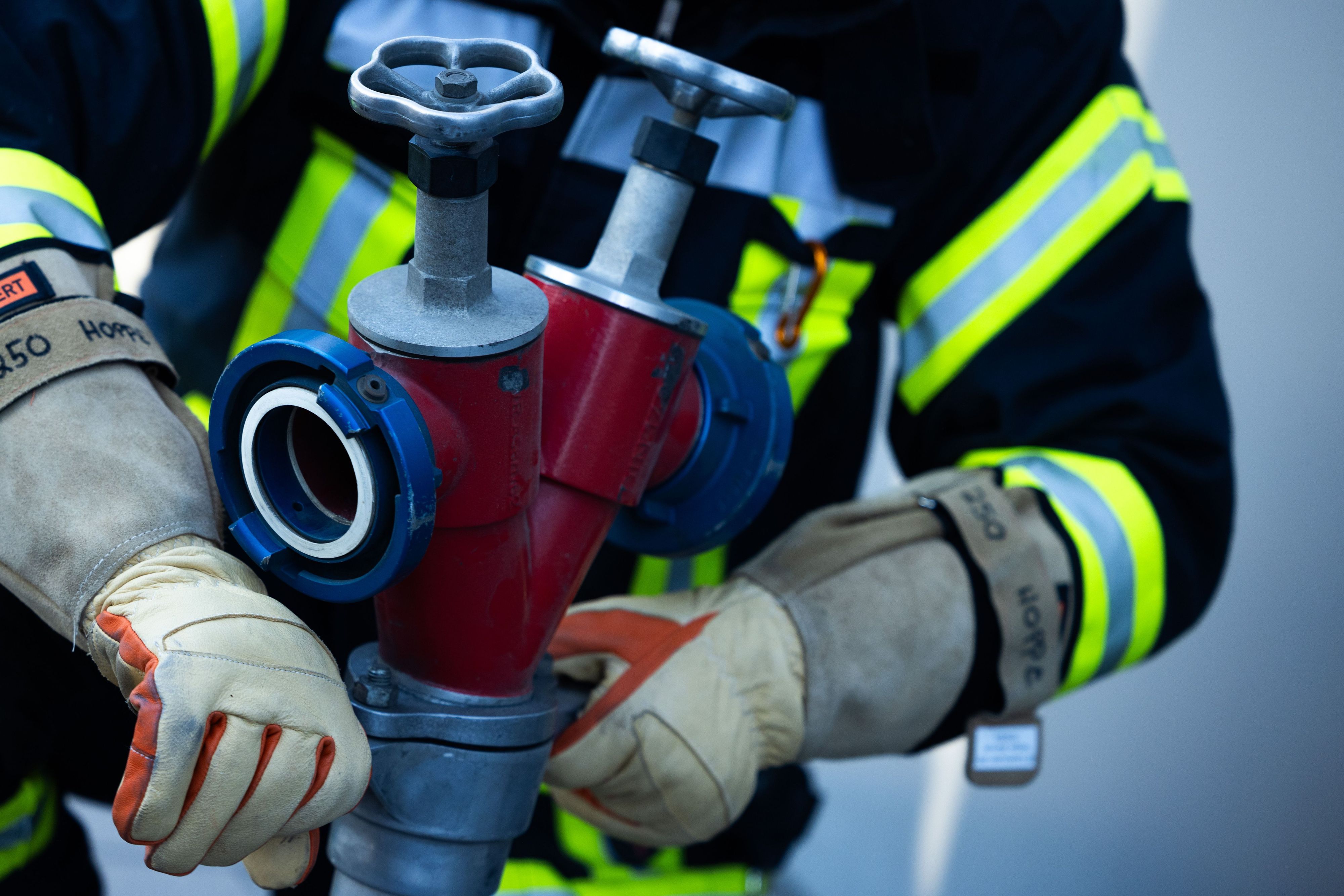 Ein Feuerwehrmann montiert einen Schlauch.