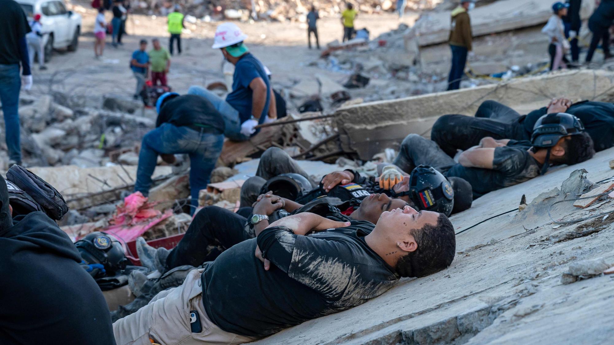Rettungskräfte und Freiwillige ruhen sich auf den Trümmern eingestürzter Gebäude in Caraballeda im Bundesstaat La Guaira, Venezuela, aus.