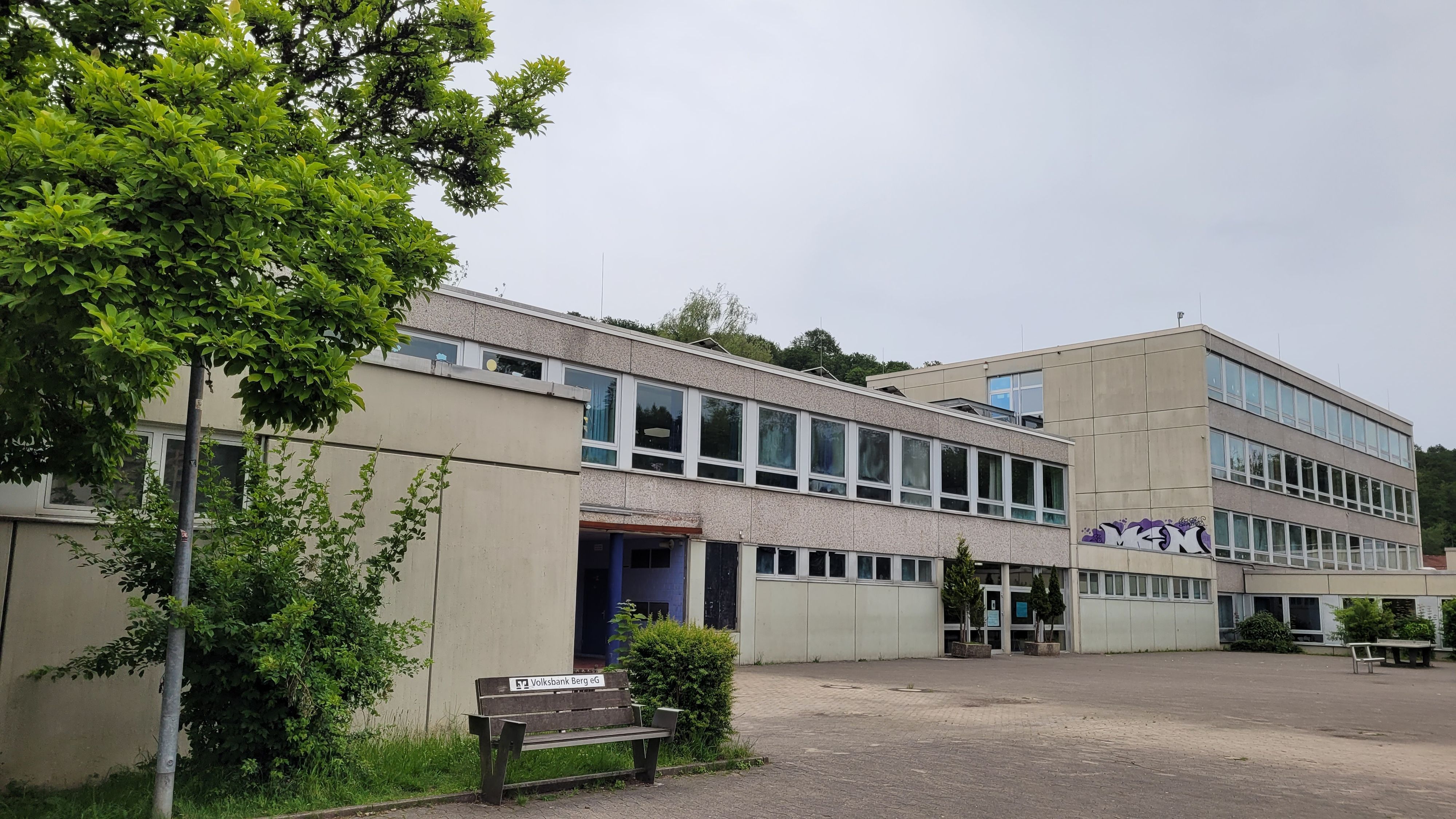 Ein weißes Flachdachgebäude, vier Stockwerke, daran angebaut eins mit zwei Stockwerken.
