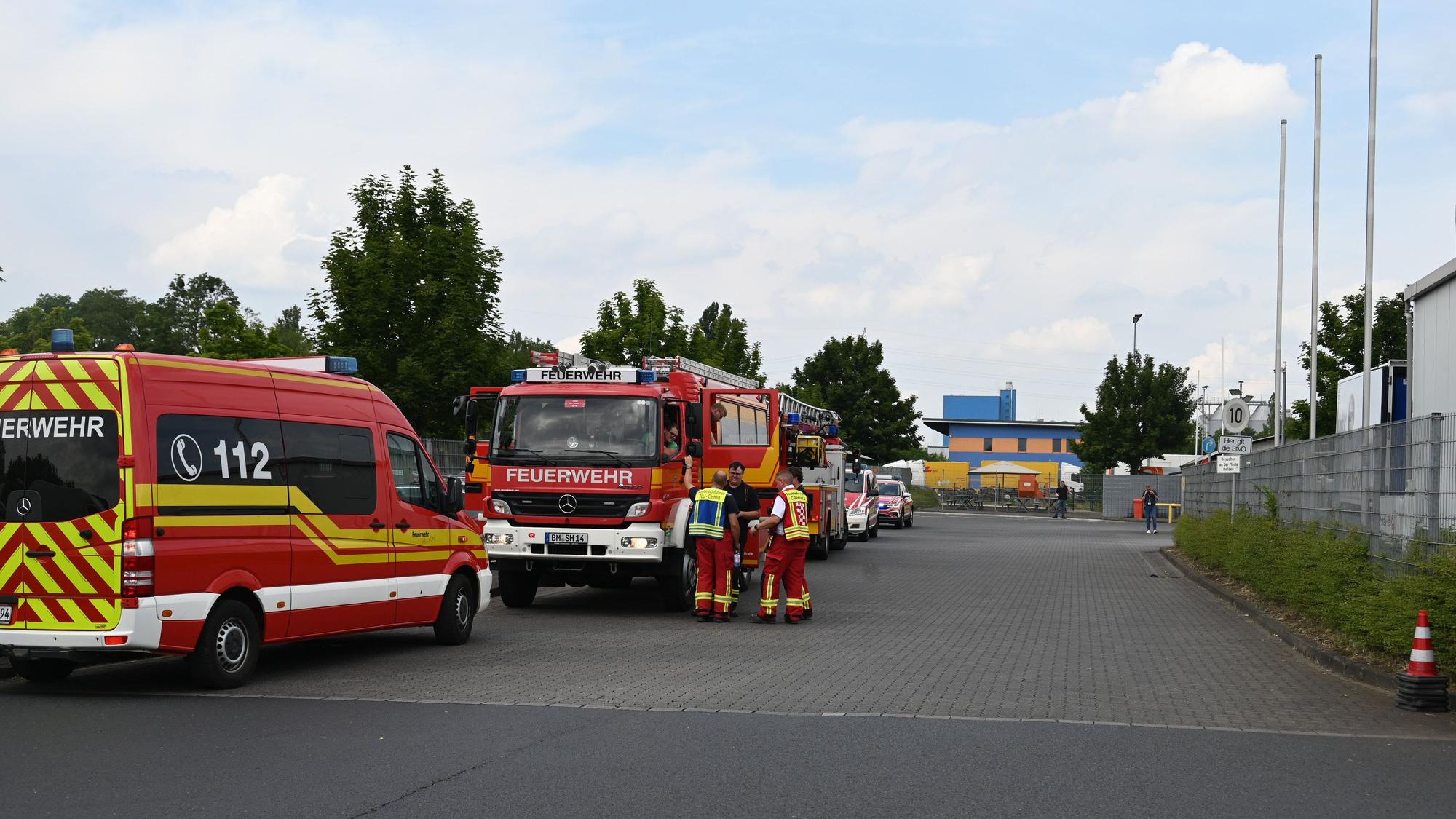 Vor der Einfahrt zur Firma stehen mehrere Feuerwehrfahrzeuge.