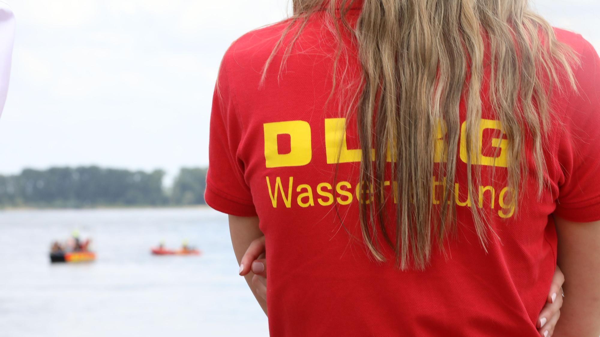 Ein Mitglied der Deutschen-Lebens-Rettungs-Gesellschaft (DLRG) beobachtet eine Rettungsübung auf dem Rhein.