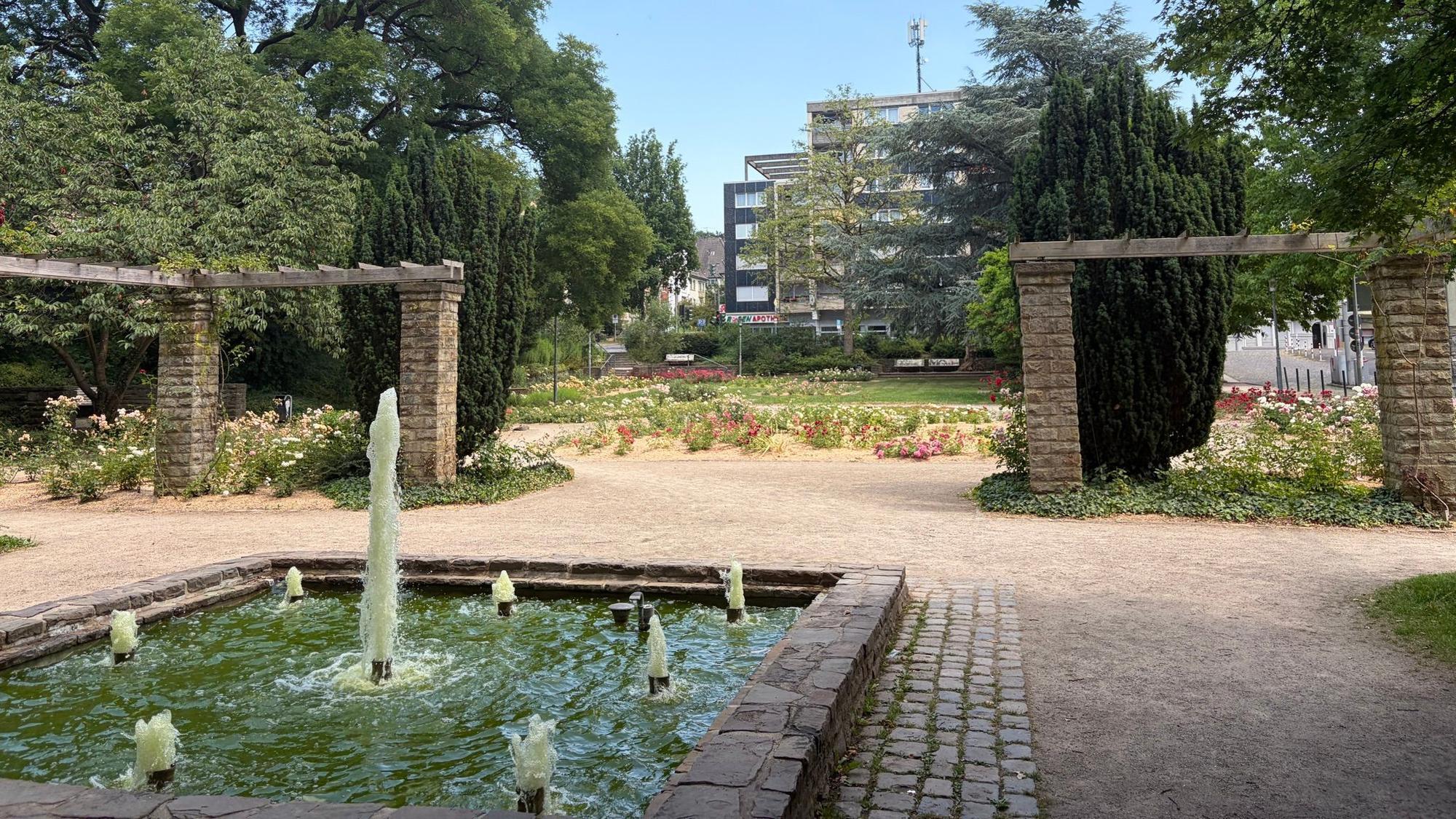 Im Gladbacher Rosengarten sprudelt ein Brunnen.
