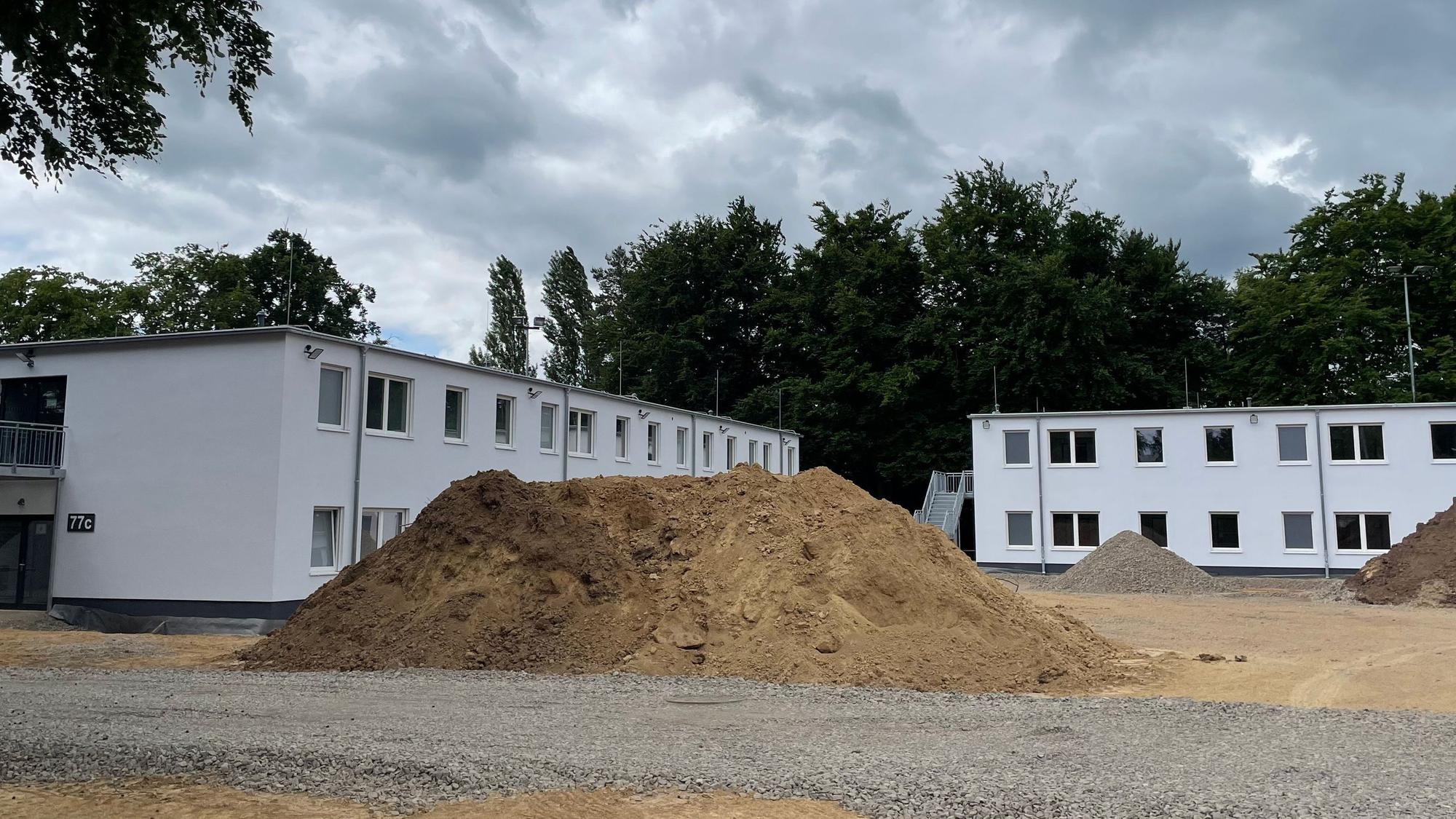 Zwei Gebäudekörper mit weißer Fassade.