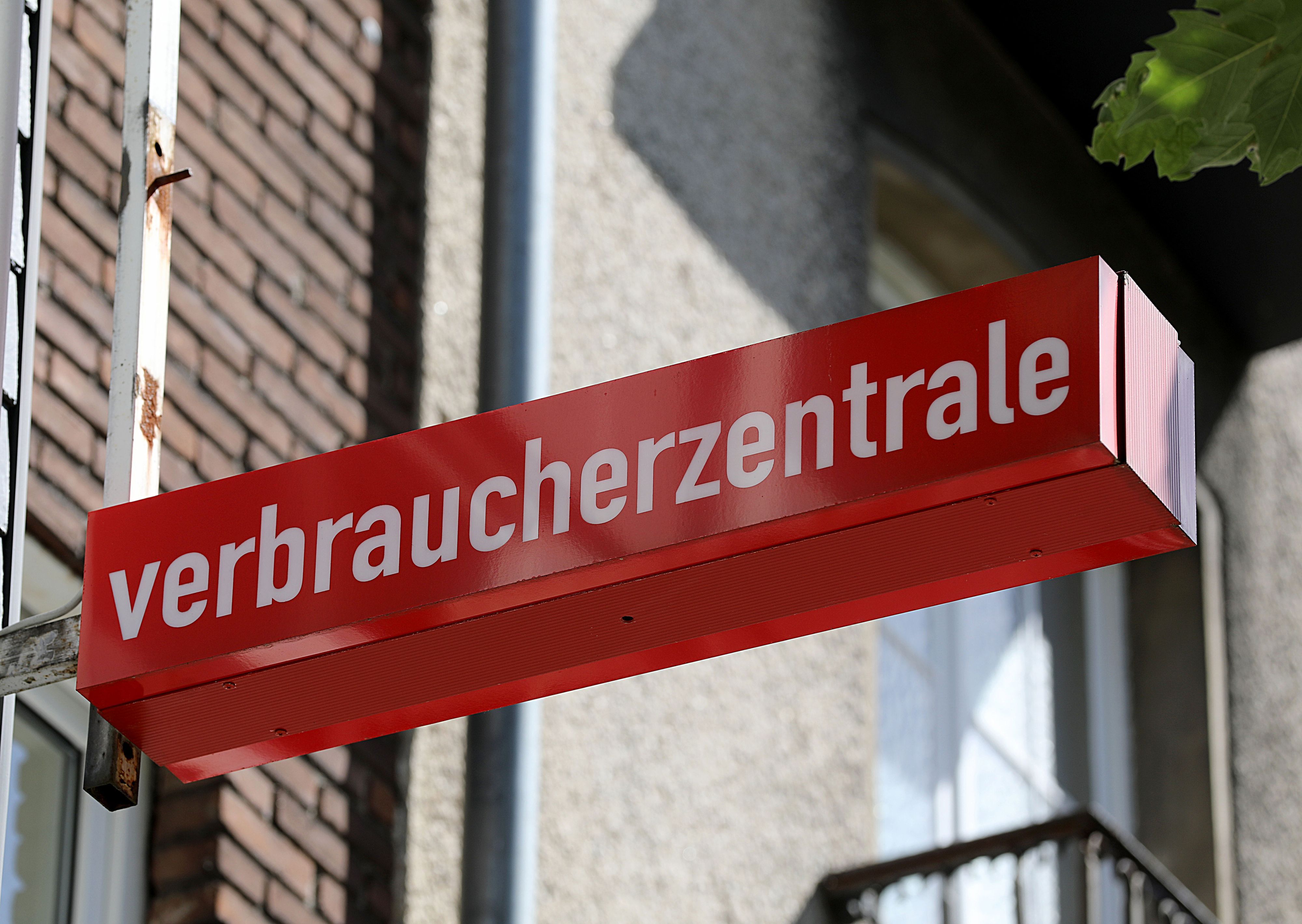 Ein Schild der Verbraucherzentrale ist an einem Gebäude befestigt.