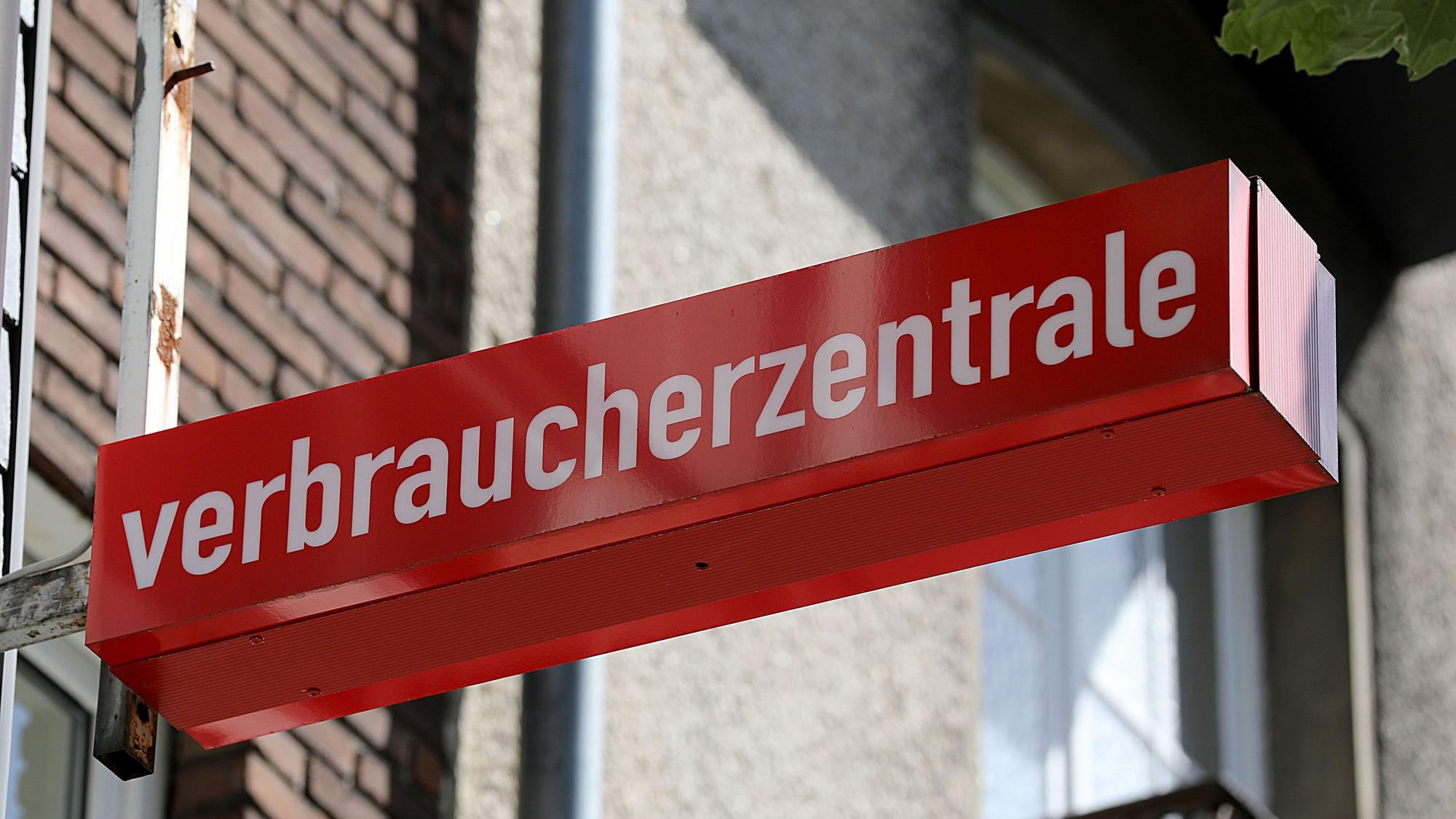 Ein Schild der Verbraucherzentrale ist an einem Gebäude befestigt.