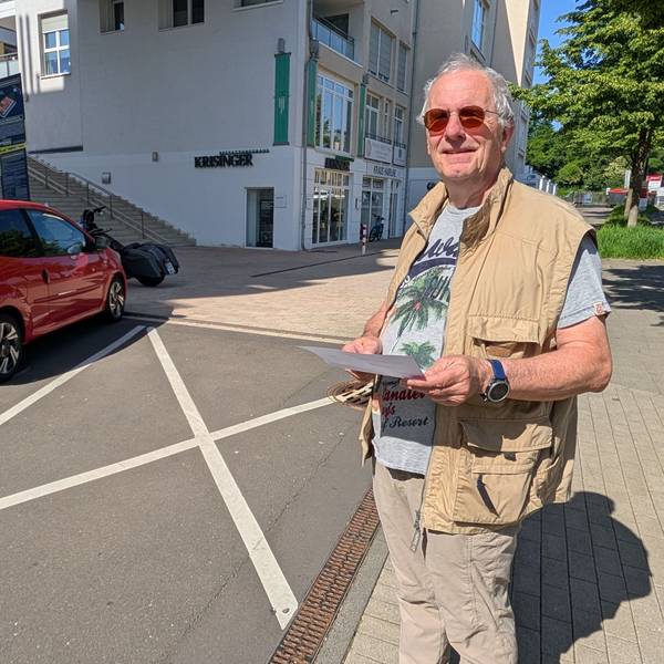 Das Foto zeigt den Hürther mit der Zahlungsaufforderung vor der markierten Sperrfläche.