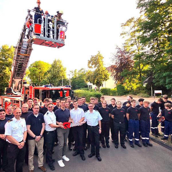Feuerwehrleute und Vertreter der Stadt Bergisch Gladbach stehen vor der neu in Dienst gestellten Drehleiter in Bergisch Gladbach-Refrath.