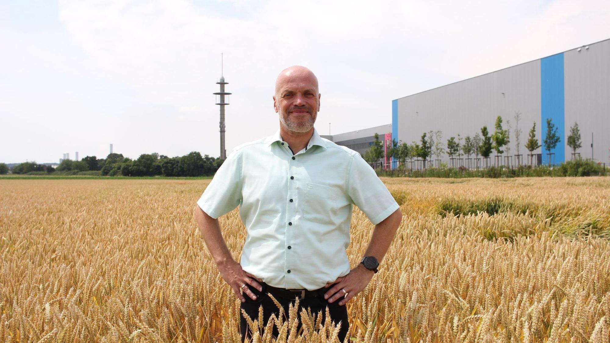 Grevenbroichs Bürgermeister Klaus Krützen (SPD) auf dem Grundstück, wo noch ein Weizenfeld ist - künftig soll dort das Microsoft-Rechenzentrum stehen.