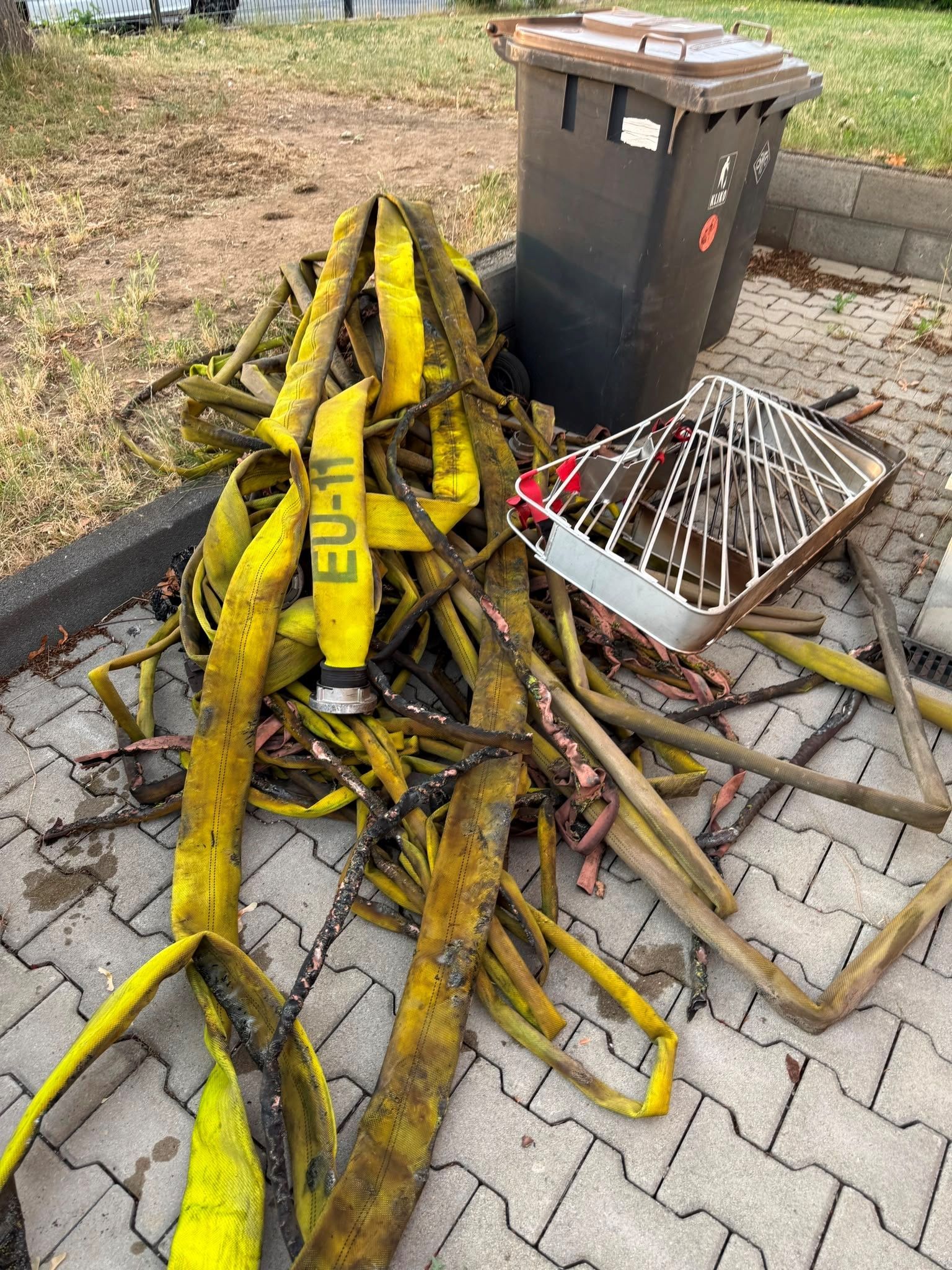 Angeschmorte Feuerwehrschläuche liegen auf einem Haufen.