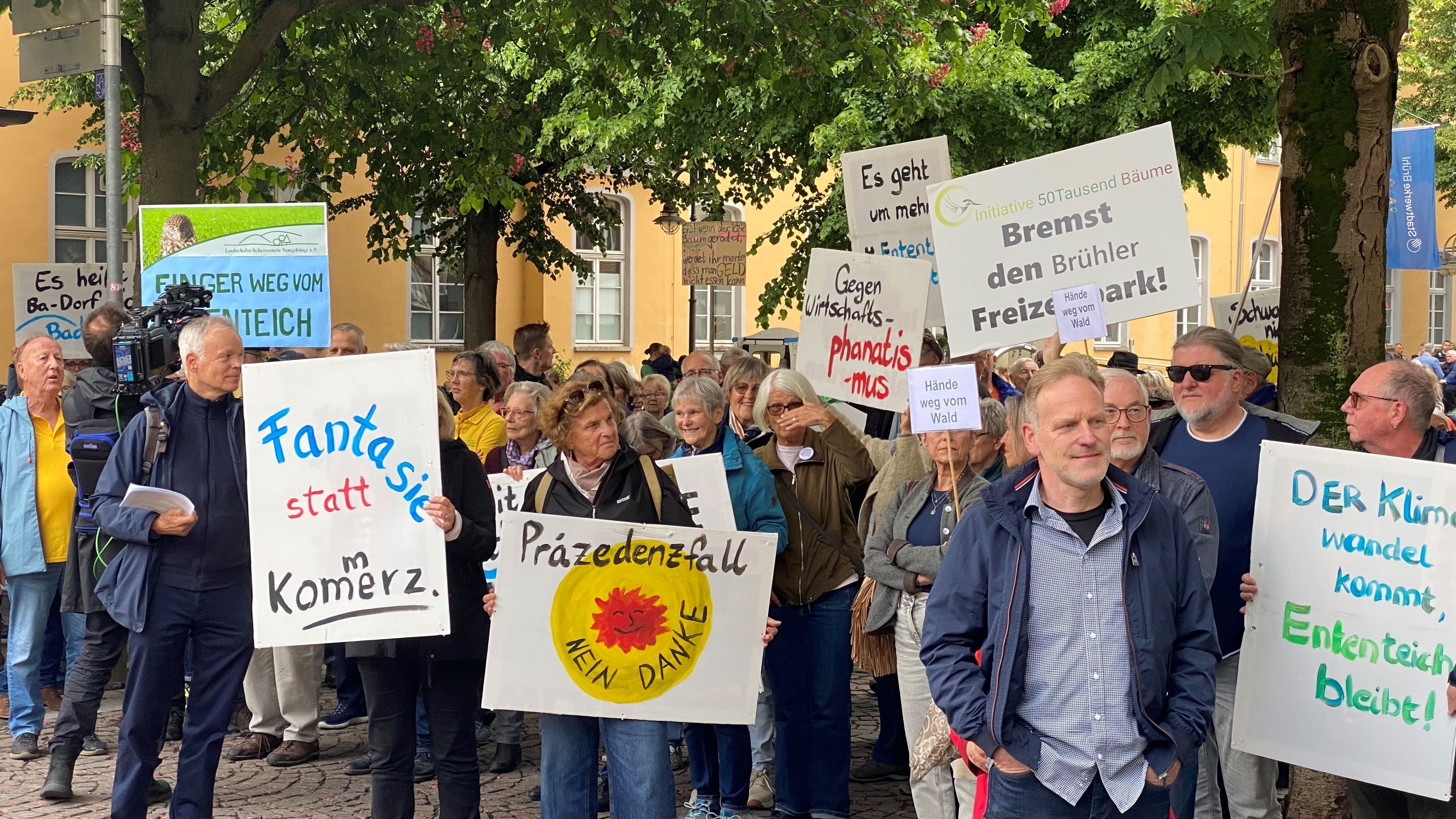 Zu sehen sind Demonstranten, sie halten Plakate und Transparente hoch.