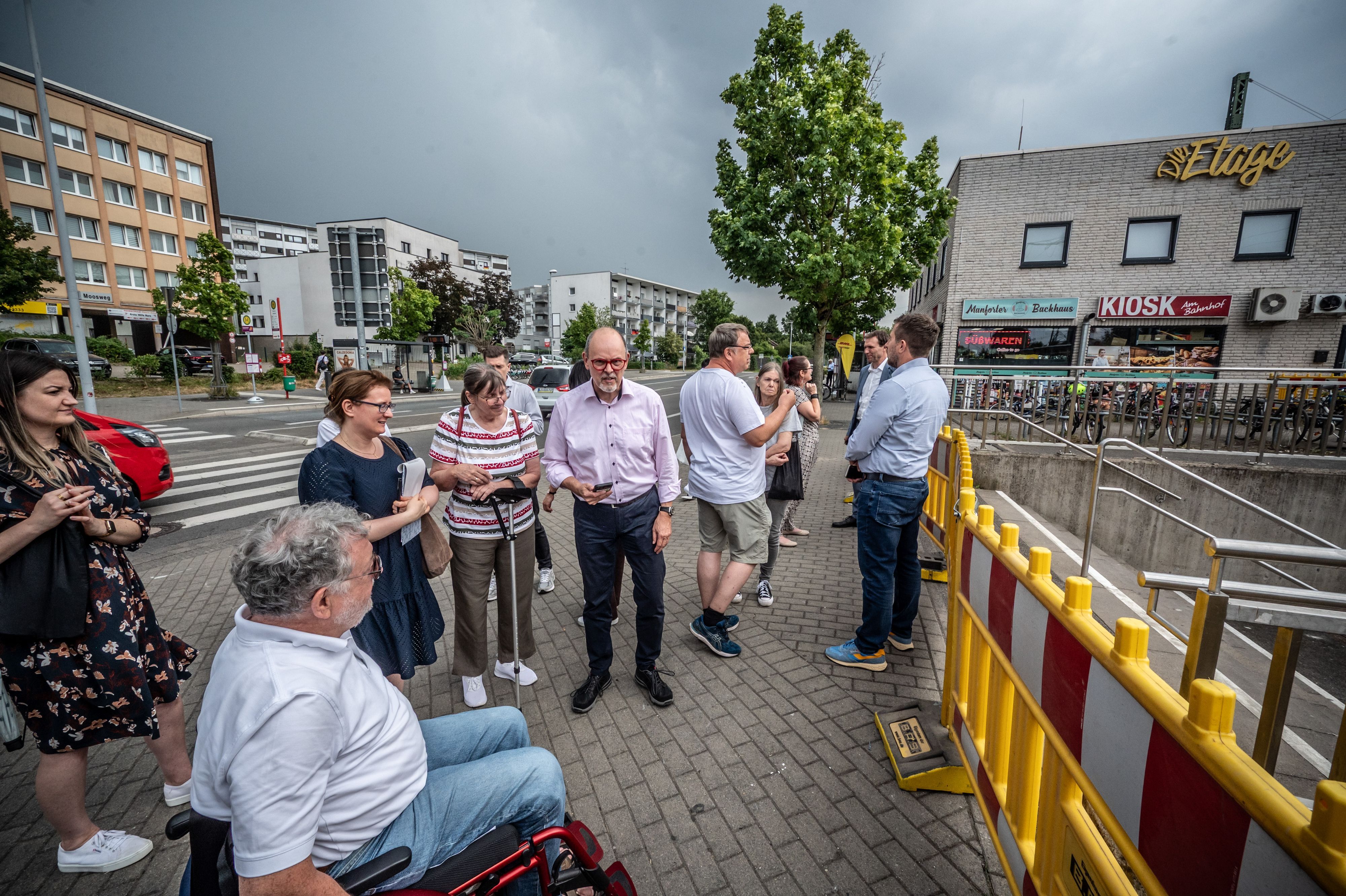 Eine Runde mit Politik, Stadtverwaltung, Bahn und Behindertenbeirat steht am Manforter Bahnhof.  Bild: Ralf Krieger