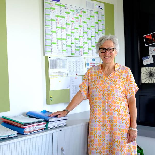 Iris Poth mit einem orange-gemusterten Sommerkleid in ihrem Büro in der Euskirchener Kreisverwaltung.