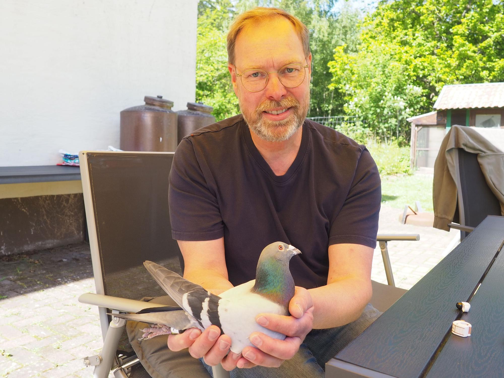 Ein Mann hält eine Taube in den Händen.