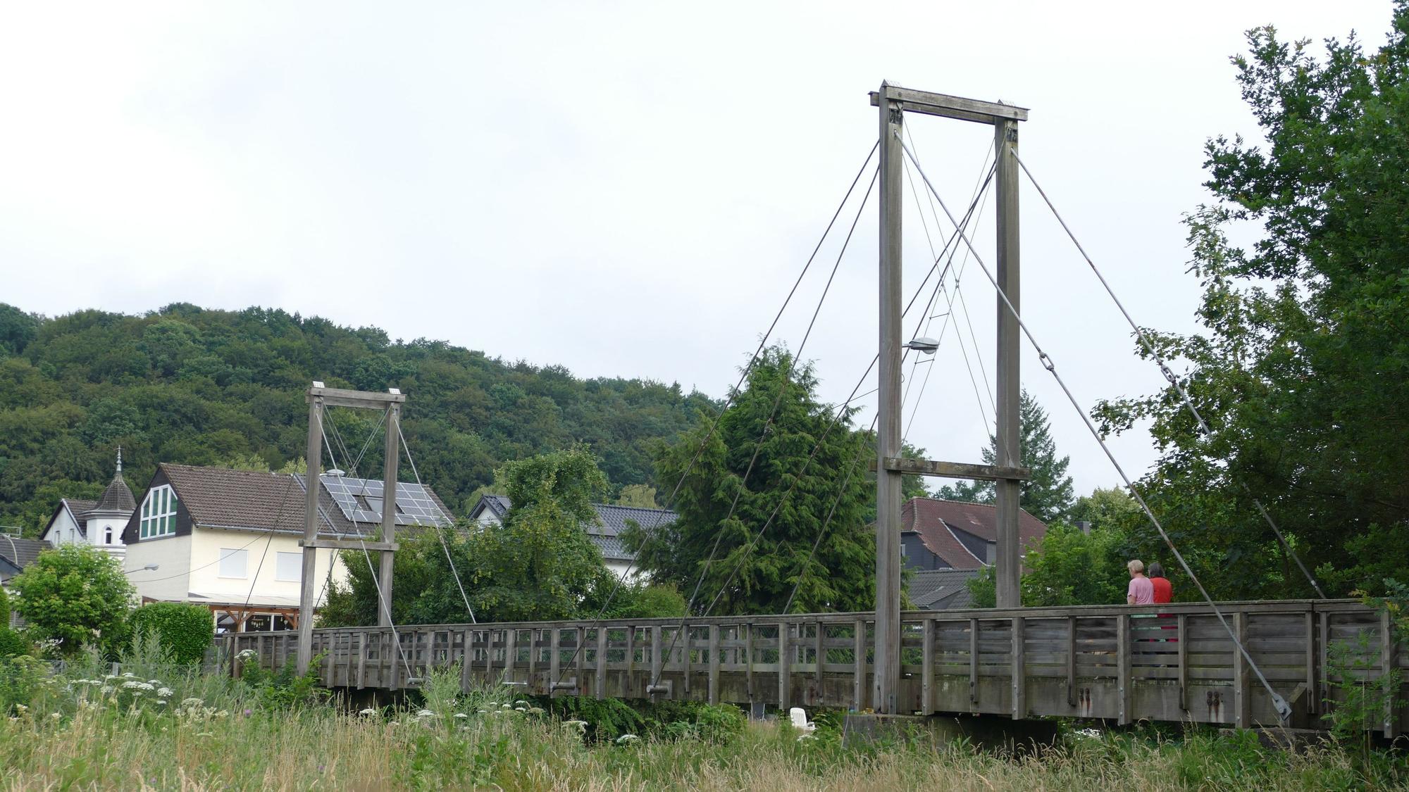 Eine hölzerne Hängebrücke.