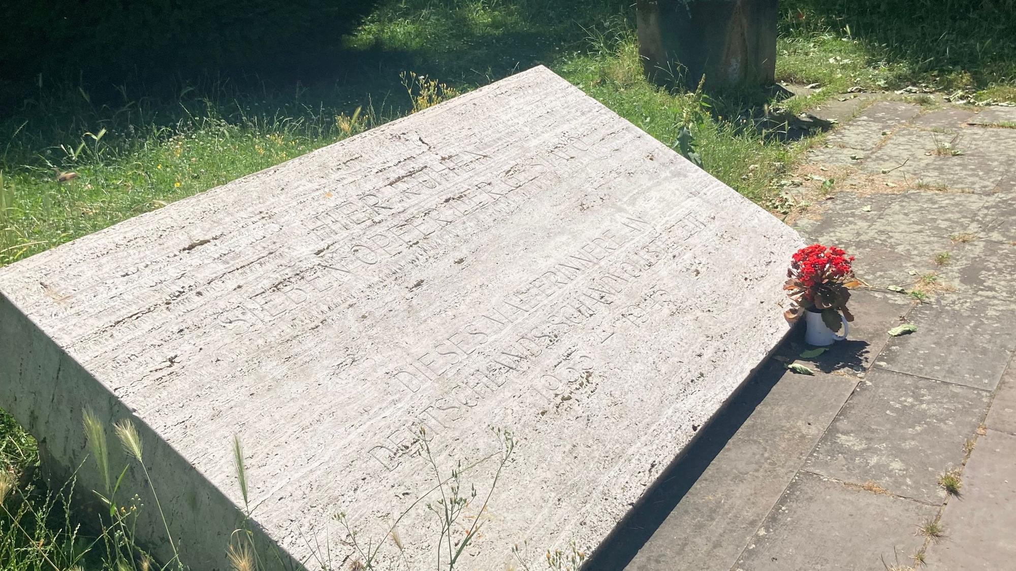 Das Bild zeigt eine Gedenktafel, deren Inschrift kaum zu lesen ist.