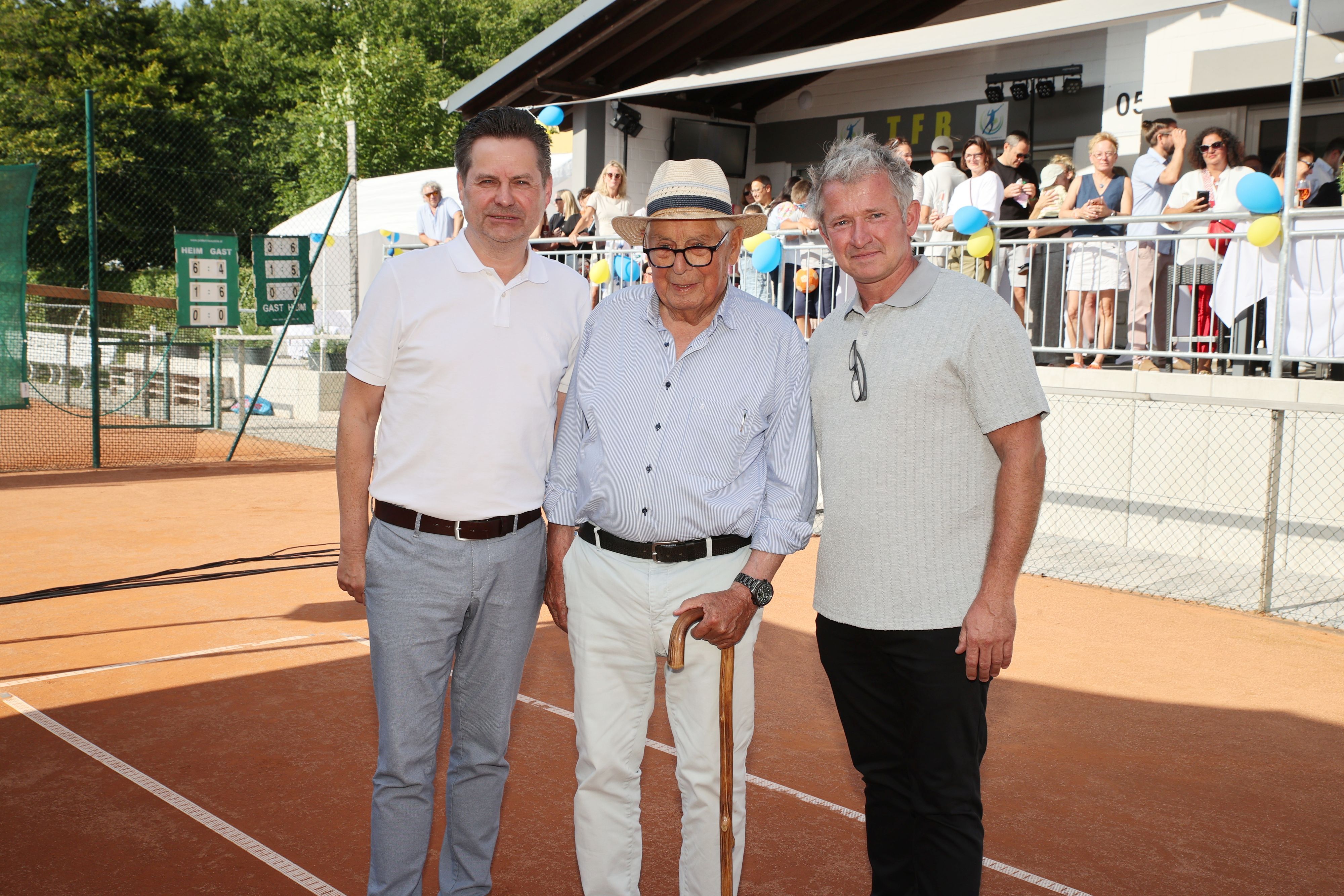 Drei Männer auf einem Tennisplatz