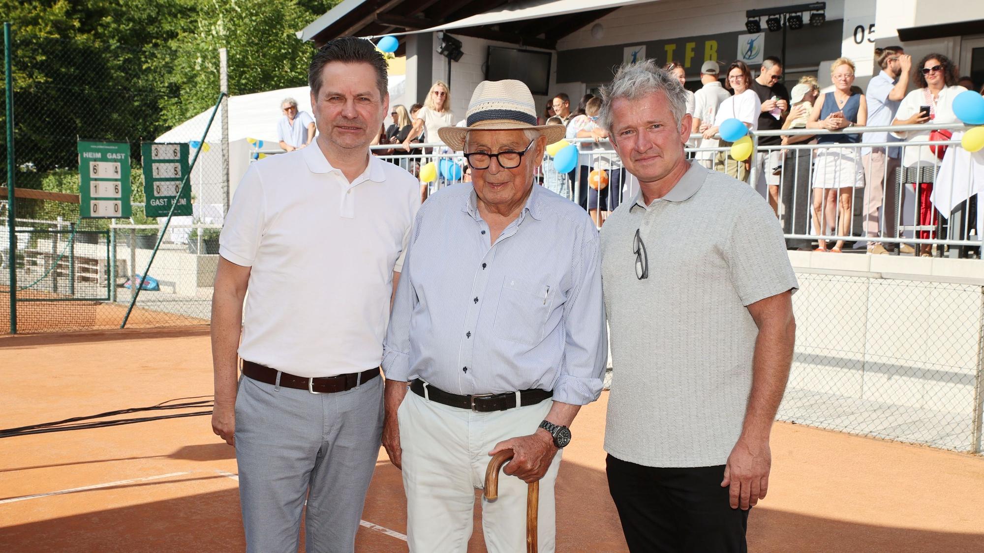 Drei Männer auf einem Tennisplatz