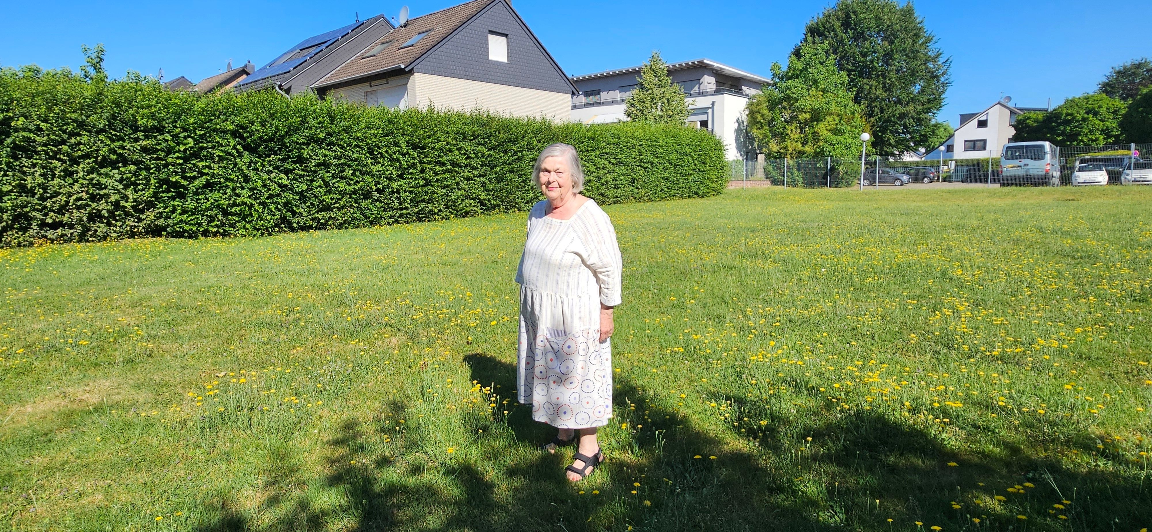 Eine Frau steht auf einer Wiese.