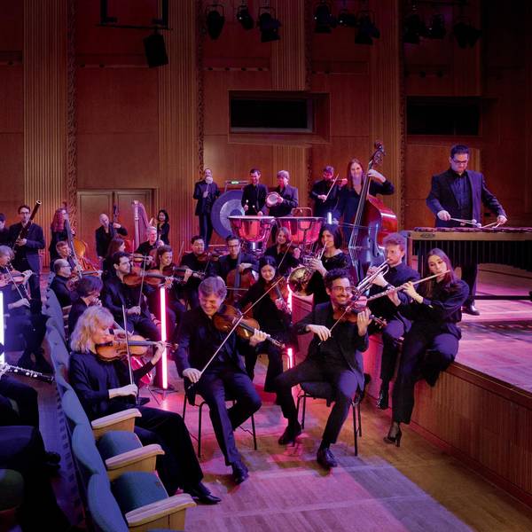 Das Ensemble des WDR-Funkhausorchesters sitzt in den Stuhlreihen eines Konzerthauses.