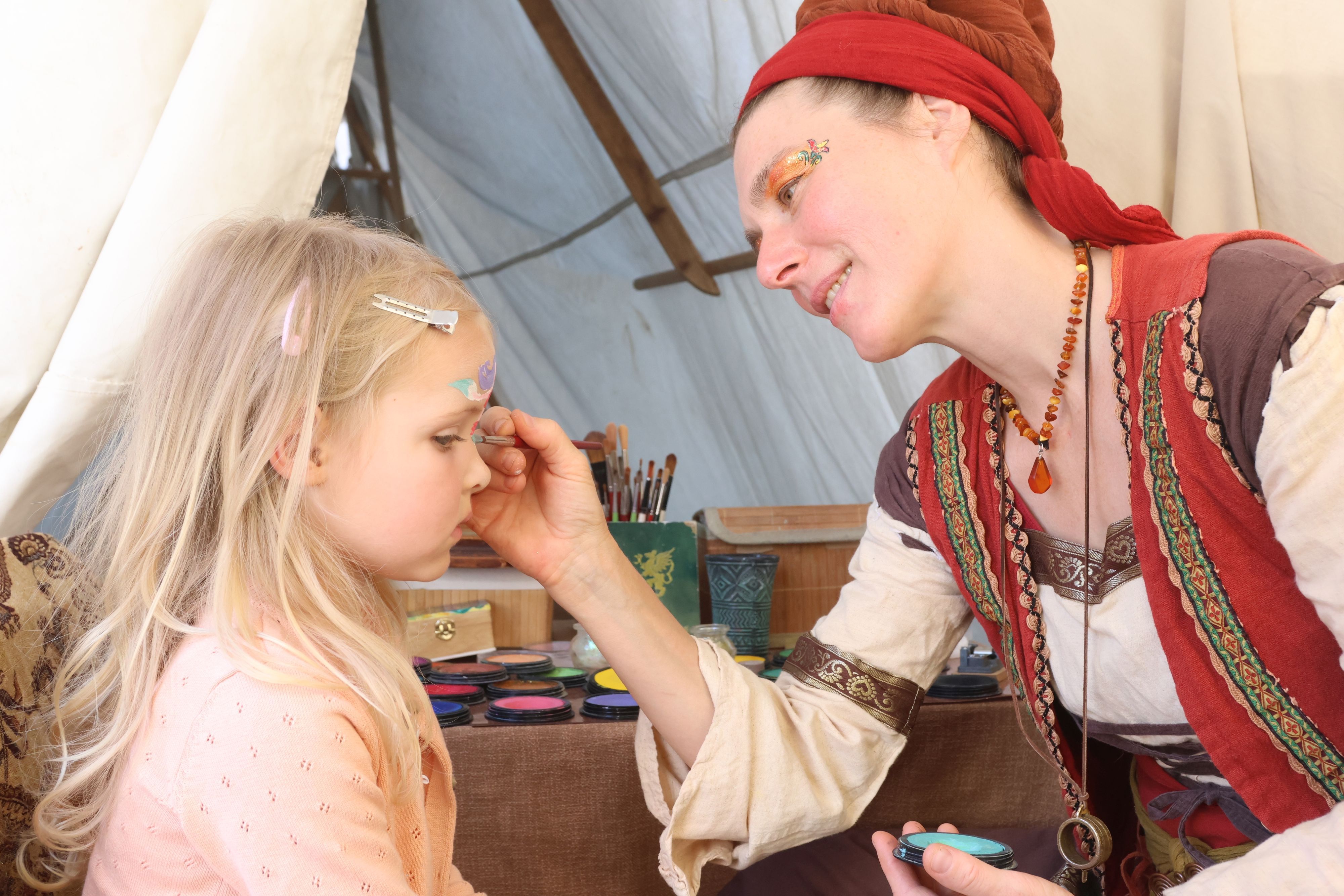 Alva (4) lässt sich vom Farbenweib Marielle schminken.