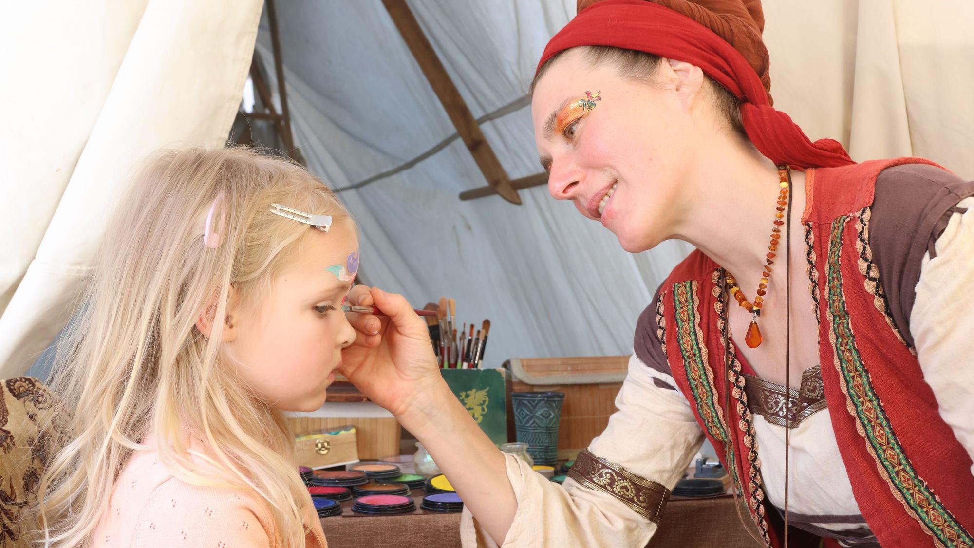 Alva (4) lässt sich vom Farbenweib Marielle schminken.