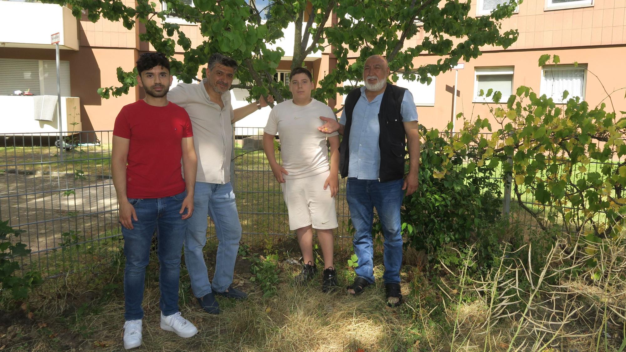 Hakan Memis, Mustafa Caglar, Neffe Eyup und Oktay Caglar (v.l.) stehen unter einem der Aprikosenbäume. Im Hintergrund ist eines der Y-Häuser zu sehen.