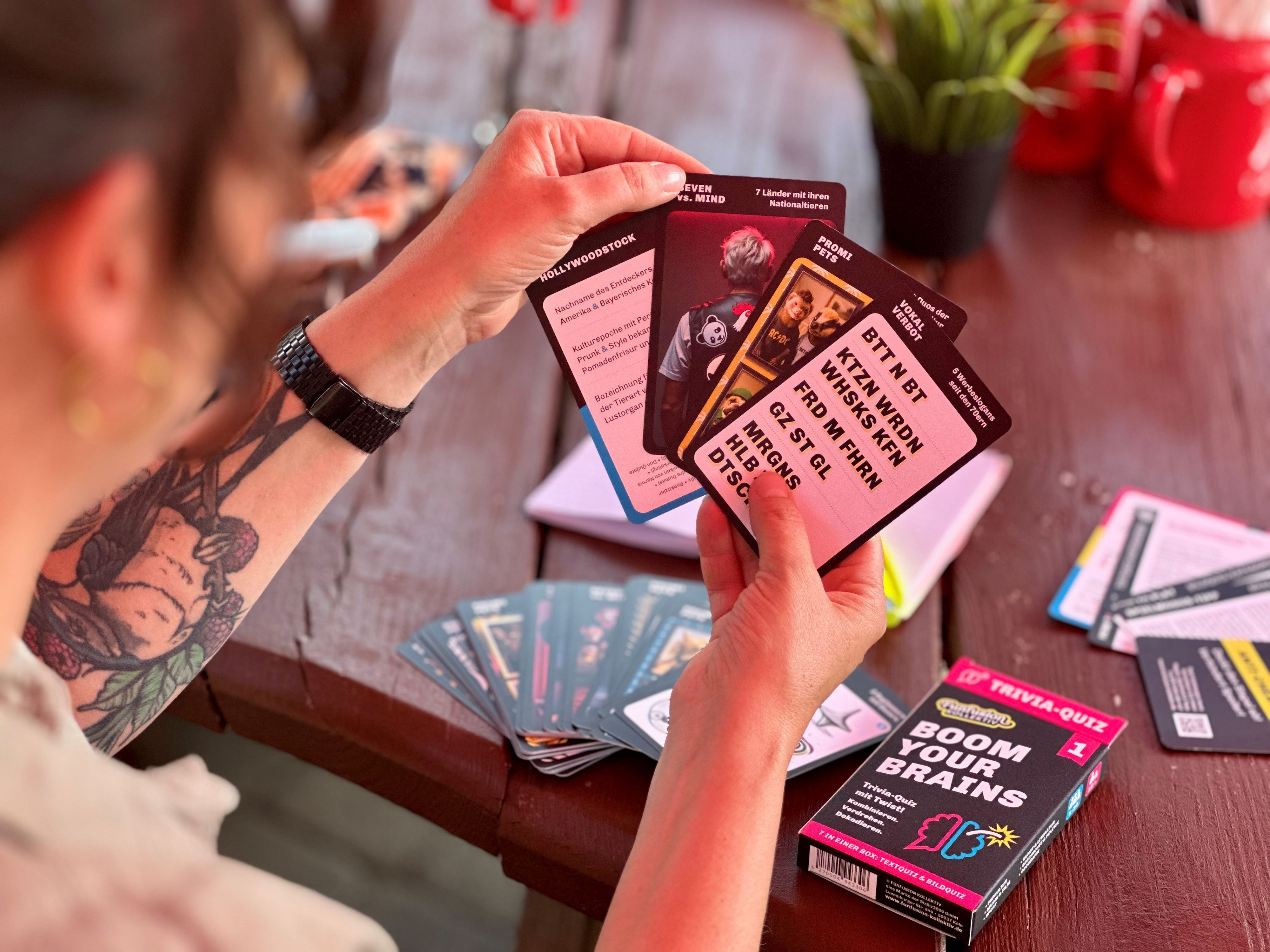 Eine Frau hält Spielkarten in einer Hand.