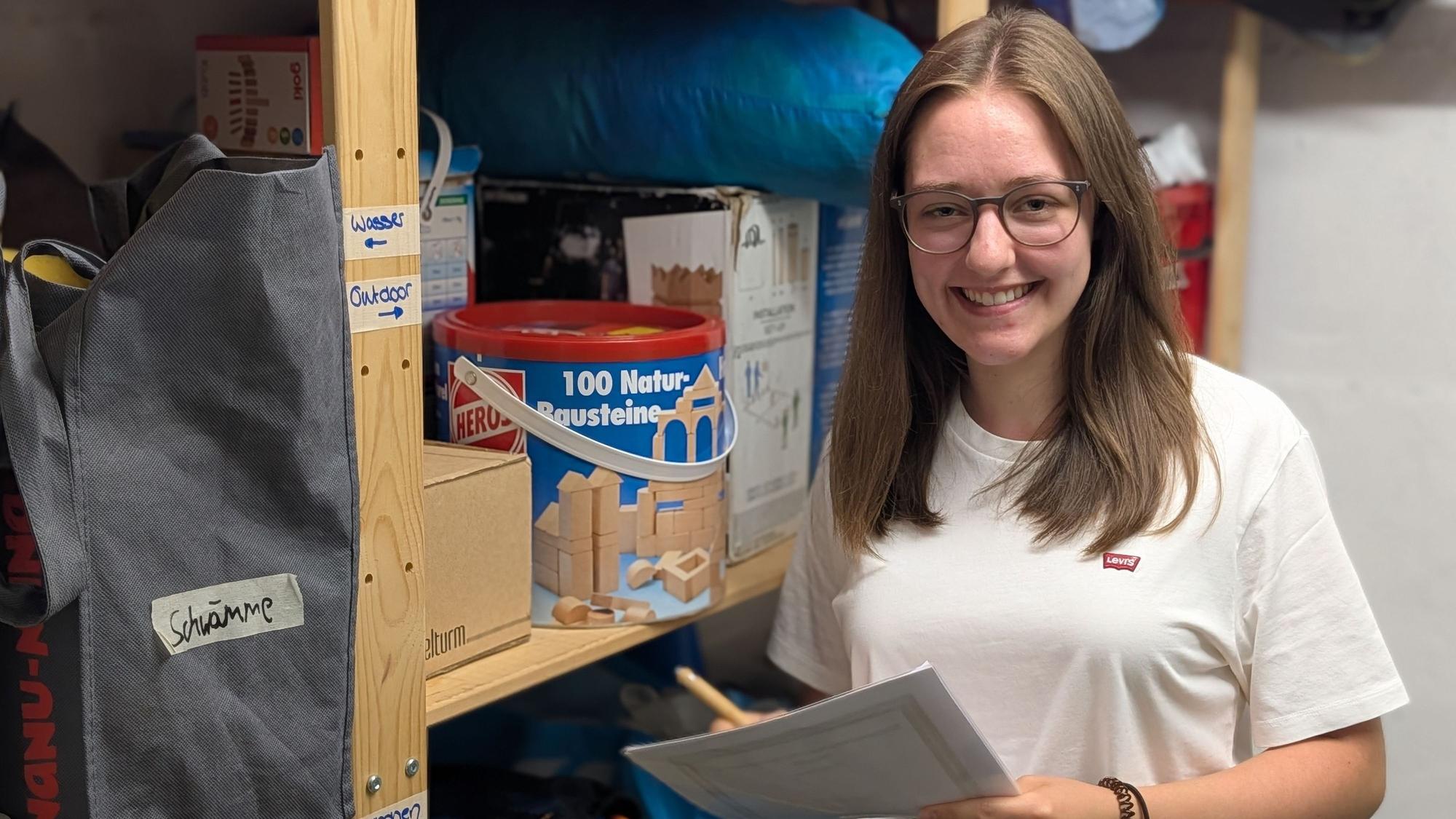 Das Foto zeigt Julia Krüger mit einer Inventarliste im Materialkeller.