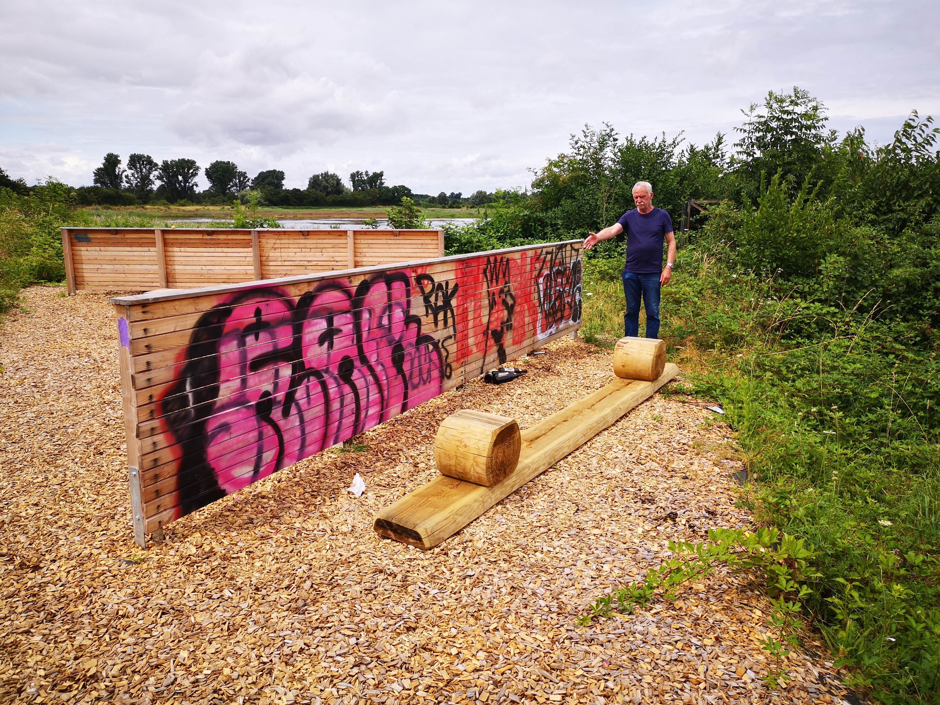 Das Foto zeigt den Naturschützer neben einer Schutzwand, die mit Graffiti beschmiert ist.