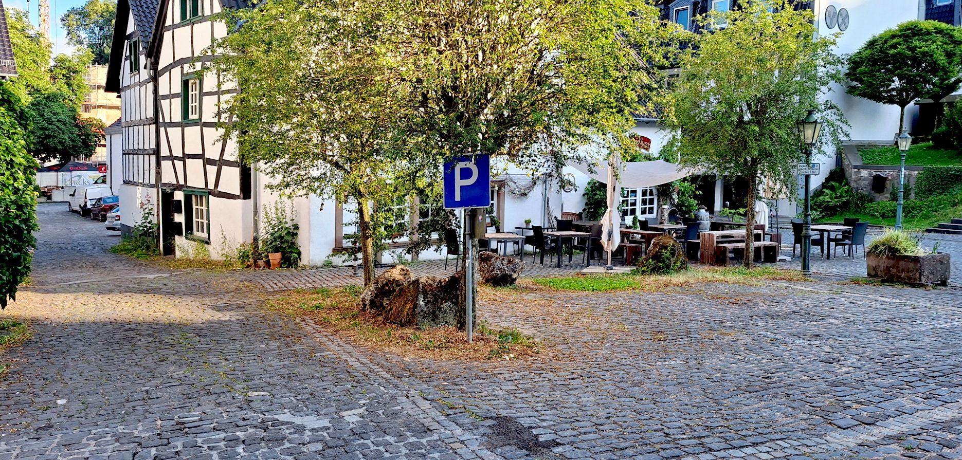 Das Pflaster des Parkplatzes ist uneben.