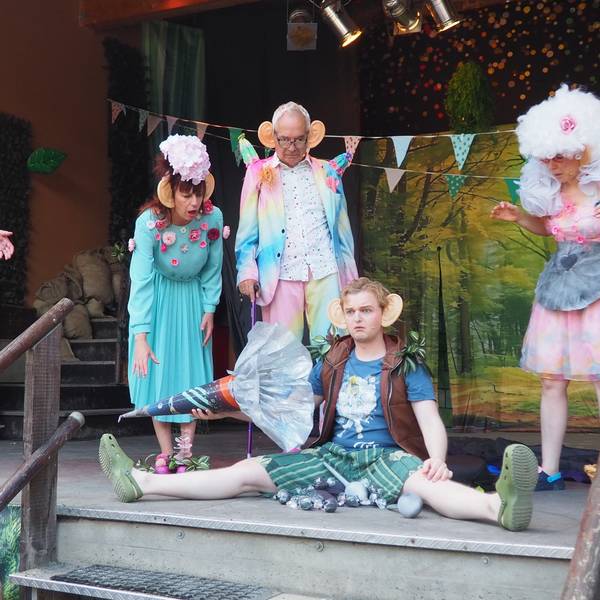 Das Ensemble des Theaters Tintenfass auf der Bühne. Ein Schauspieler sitzt und leert die Schultüte, die anderen schauen entsetzt zu.