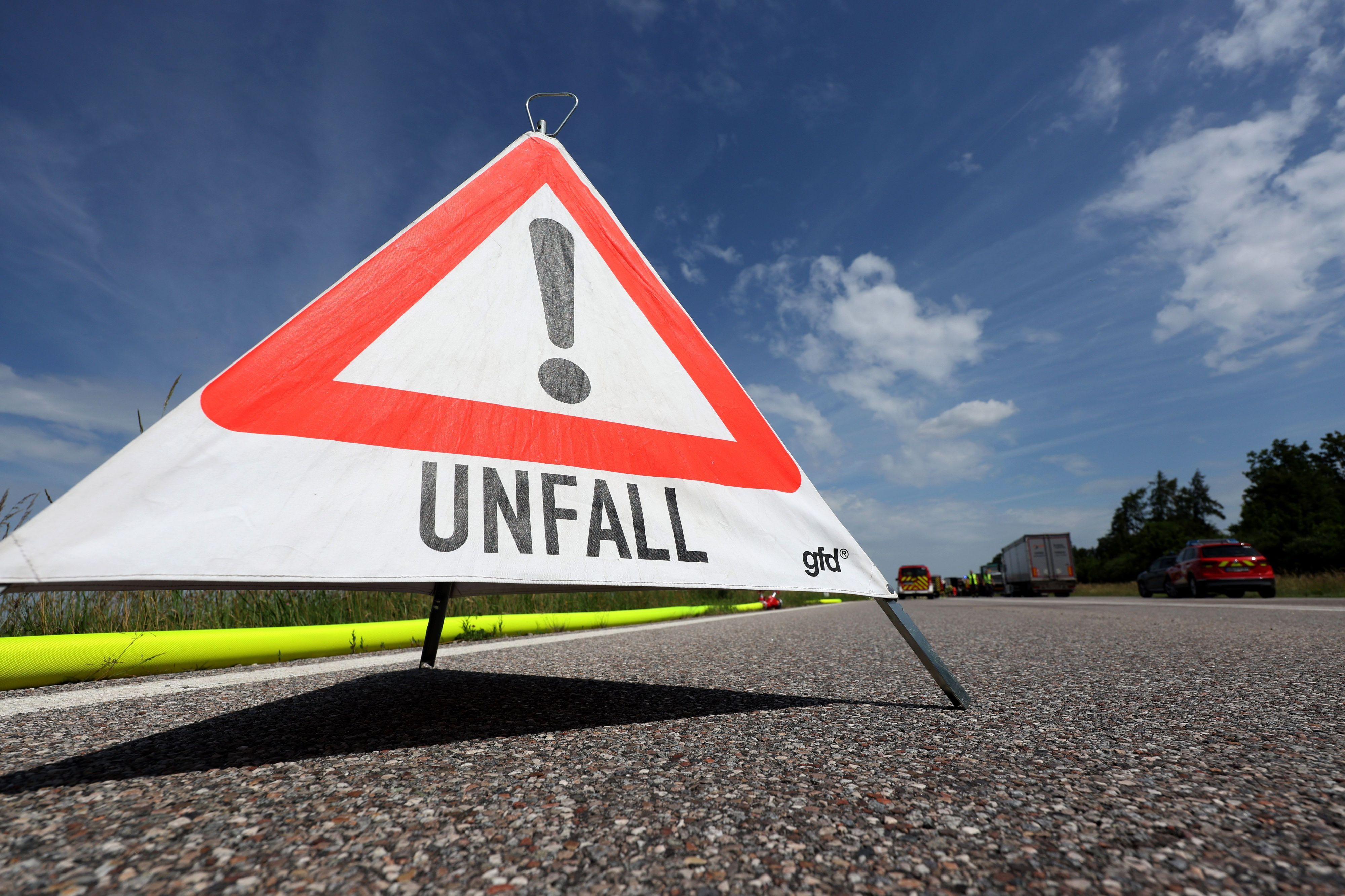 Ein Warndreieck mit der Aufschrift „Unfall“ steht auf einer Autobahn. (Symbolbild)
