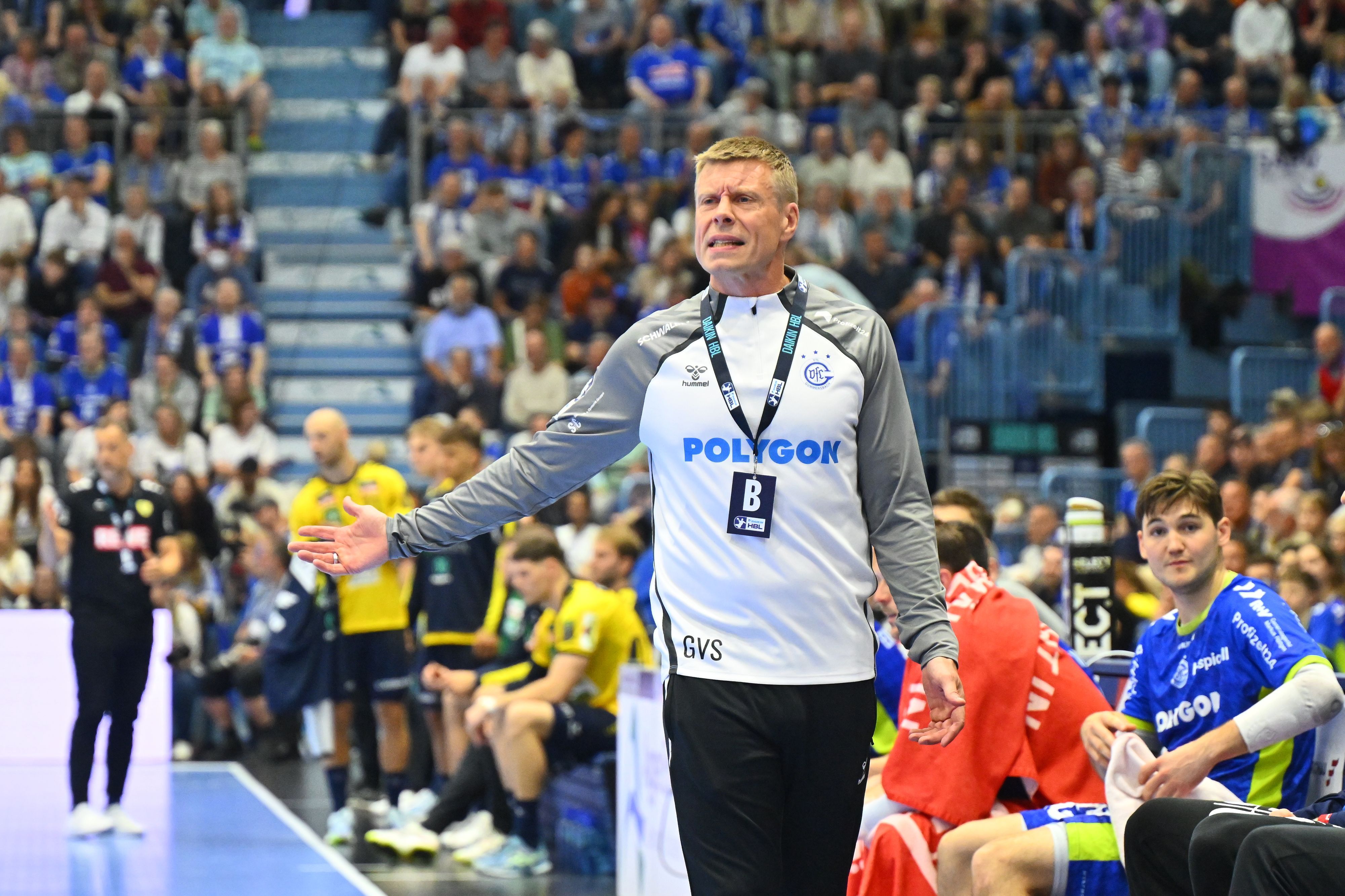 Zu sehen ist ein Handballtrainer am Spielfeldrand.