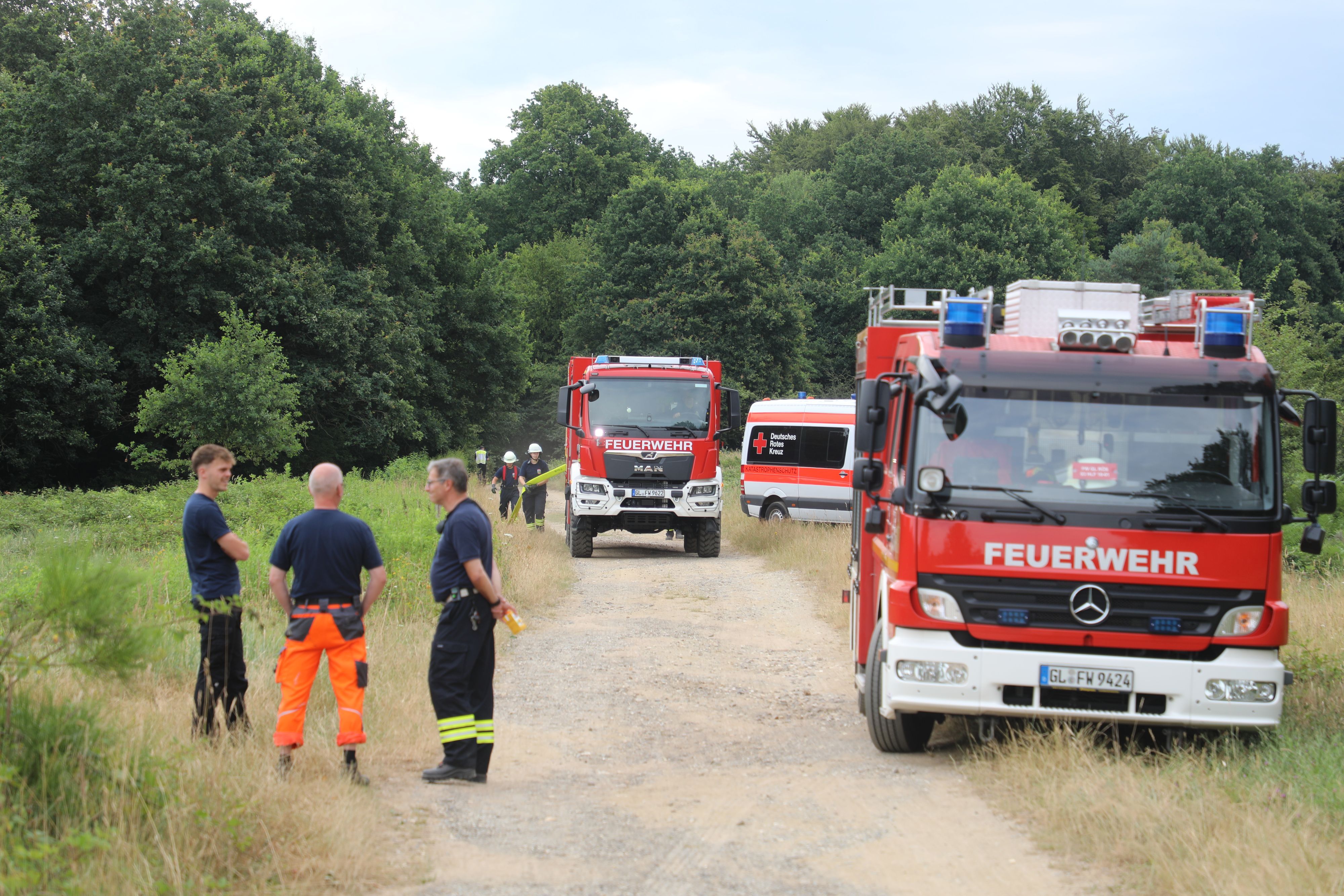 Von dem letzten großen Hydranten auf Rösrather Stadtgebiet verlegen Feuerwehrleute eine Schlauchleitung zum Brandort in die Wahner Heide.