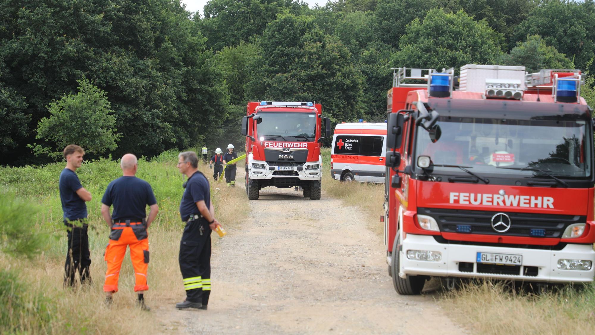 Von dem letzten großen Hydranten auf Rösrather Stadtgebiet verlegen Feuerwehrleute eine Schlauchleitung zum Brandort in die Wahner Heide.