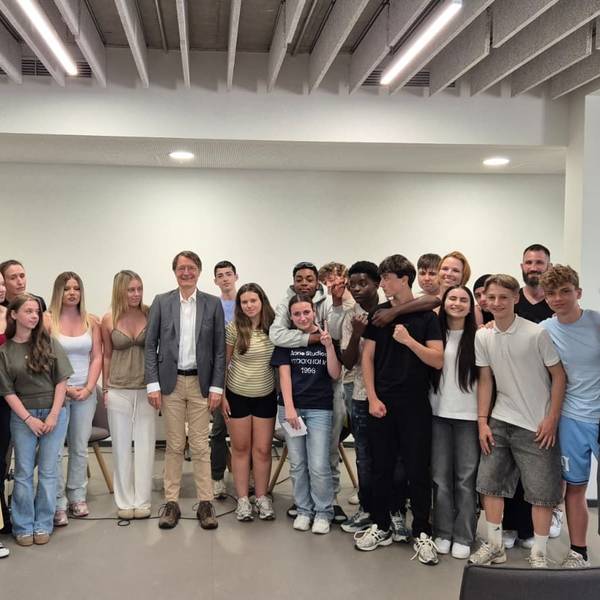 In einem Halbkreis stehen viele Schüler, mittendrin Karl Lauterbach.