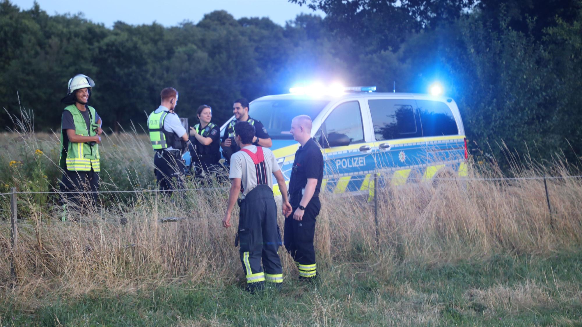 Polizei und Feuerwehr stehen auf einem Weg in der Wahner Heide.