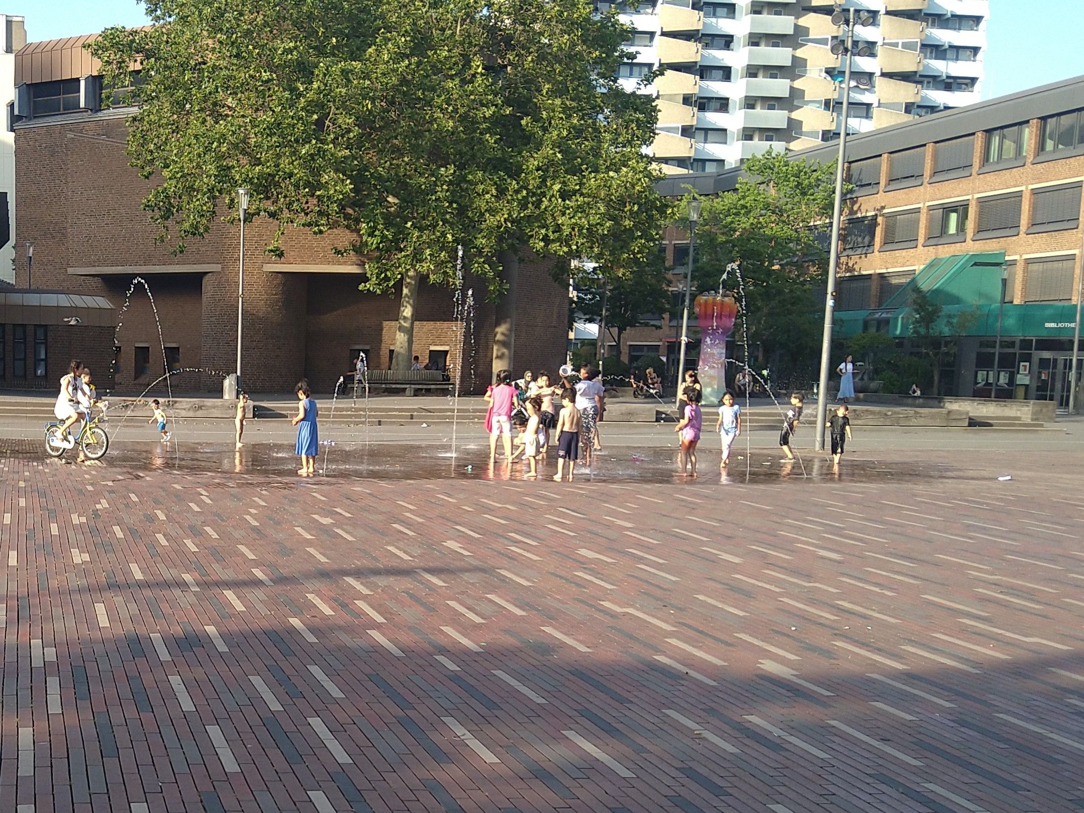 Im begehbaren Brunnen spielende Kinder auf dem Pariser Platz.