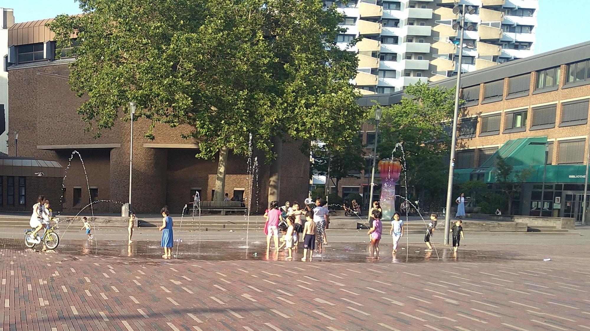 Im begehbaren Brunnen spielende Kinder auf dem Pariser Platz.