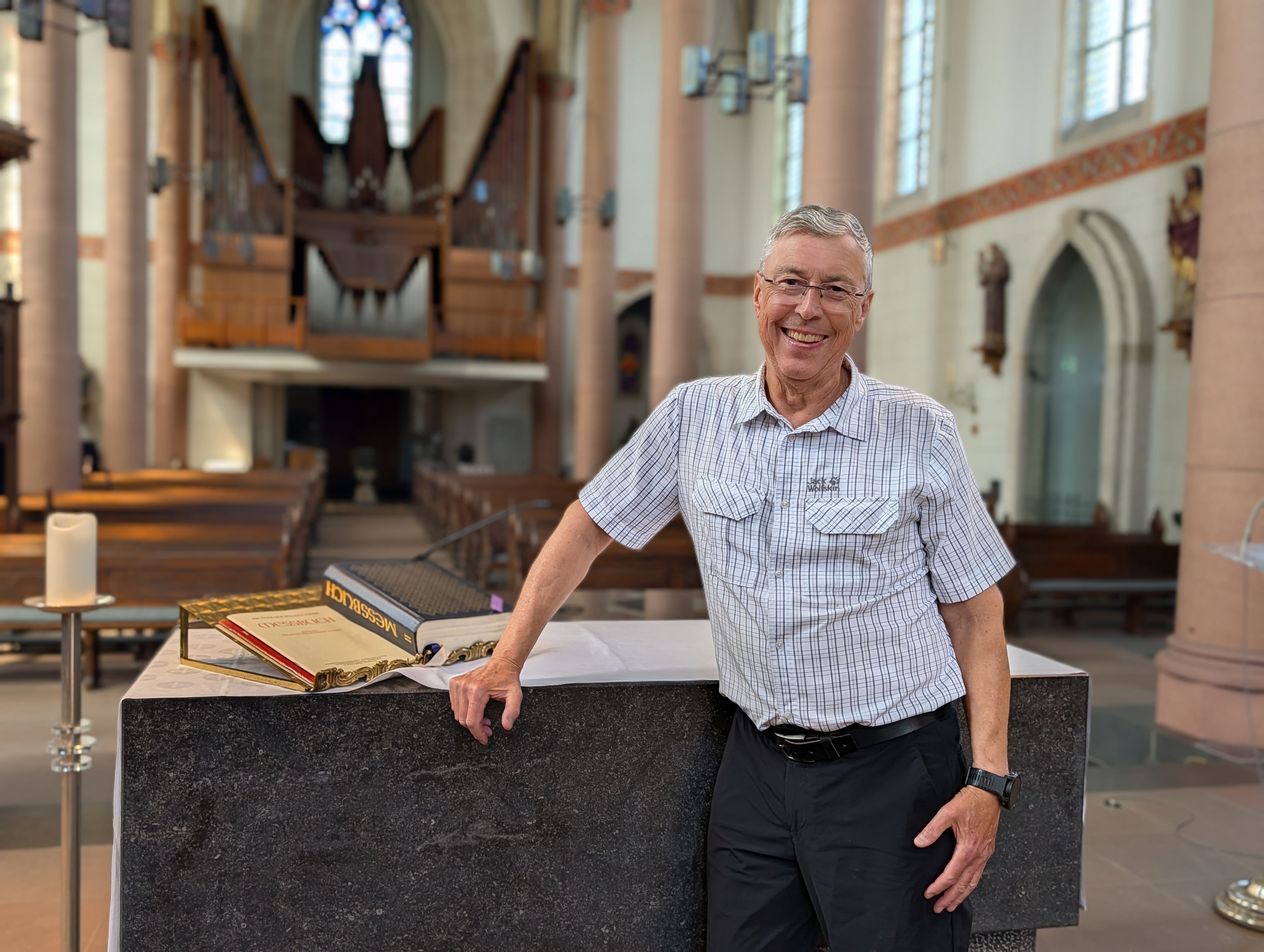 Das Foto zeigt Pfarrer Michael Tillmann am Altar vor leeren Reihen in der Pfarrkirche St. Dionysius in Gleuel.