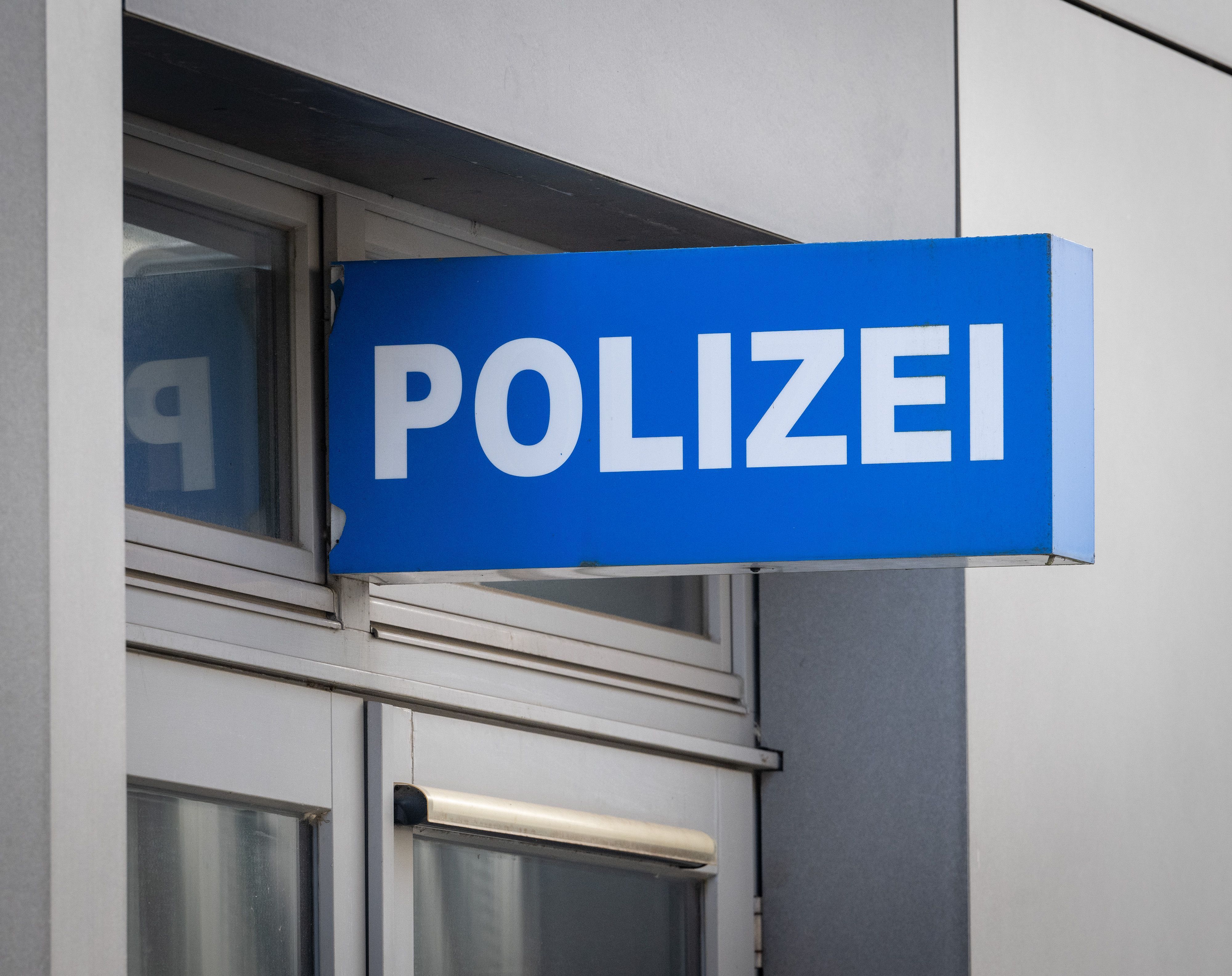 Ein Schild «Polizei» hängt an der Fassade eines Hauses.