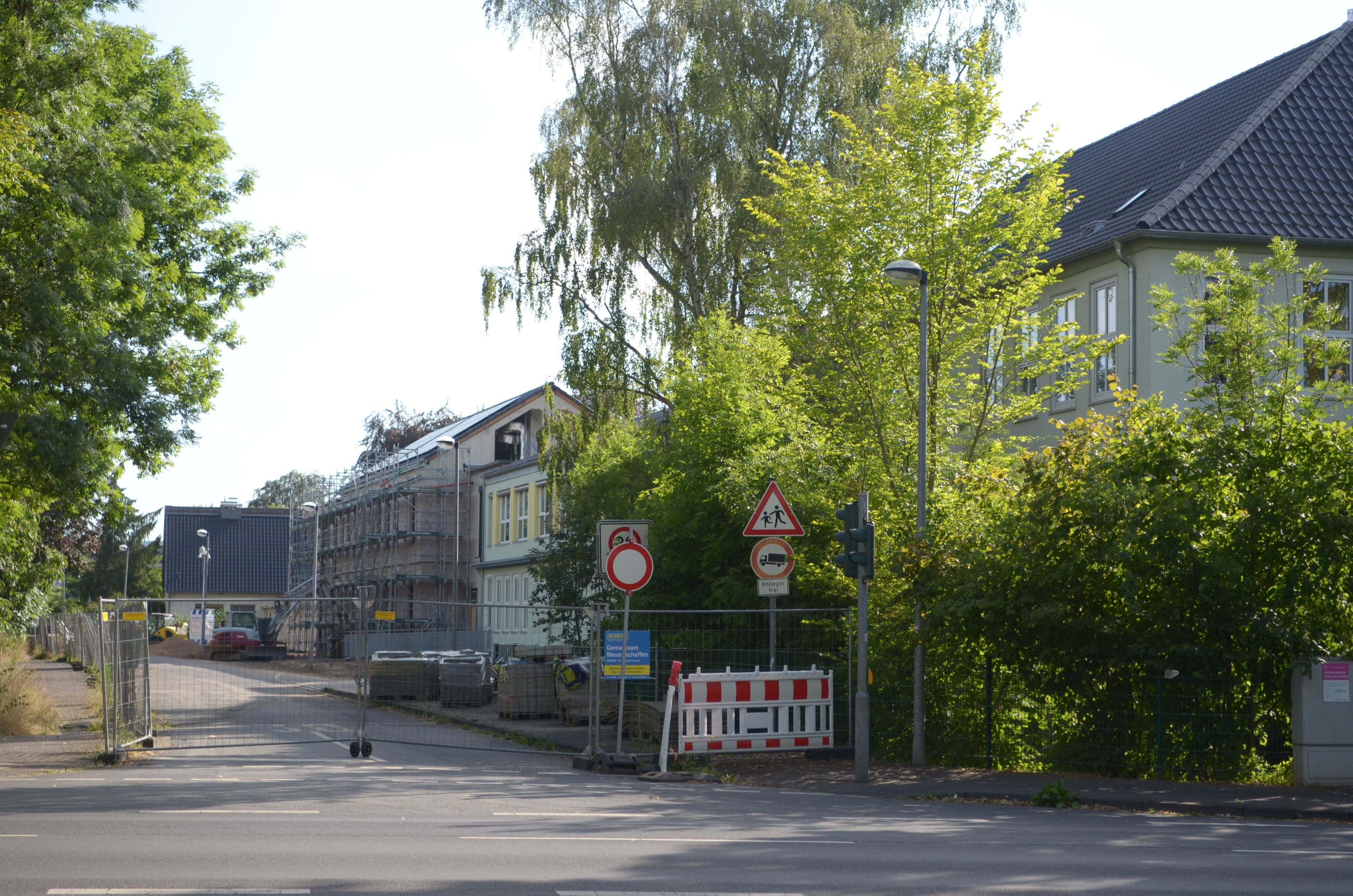 Die Straße ist mit einem Bauzaun abgesperrt. Im Hintergrund liegen die Gebäude der Franziskusschule.