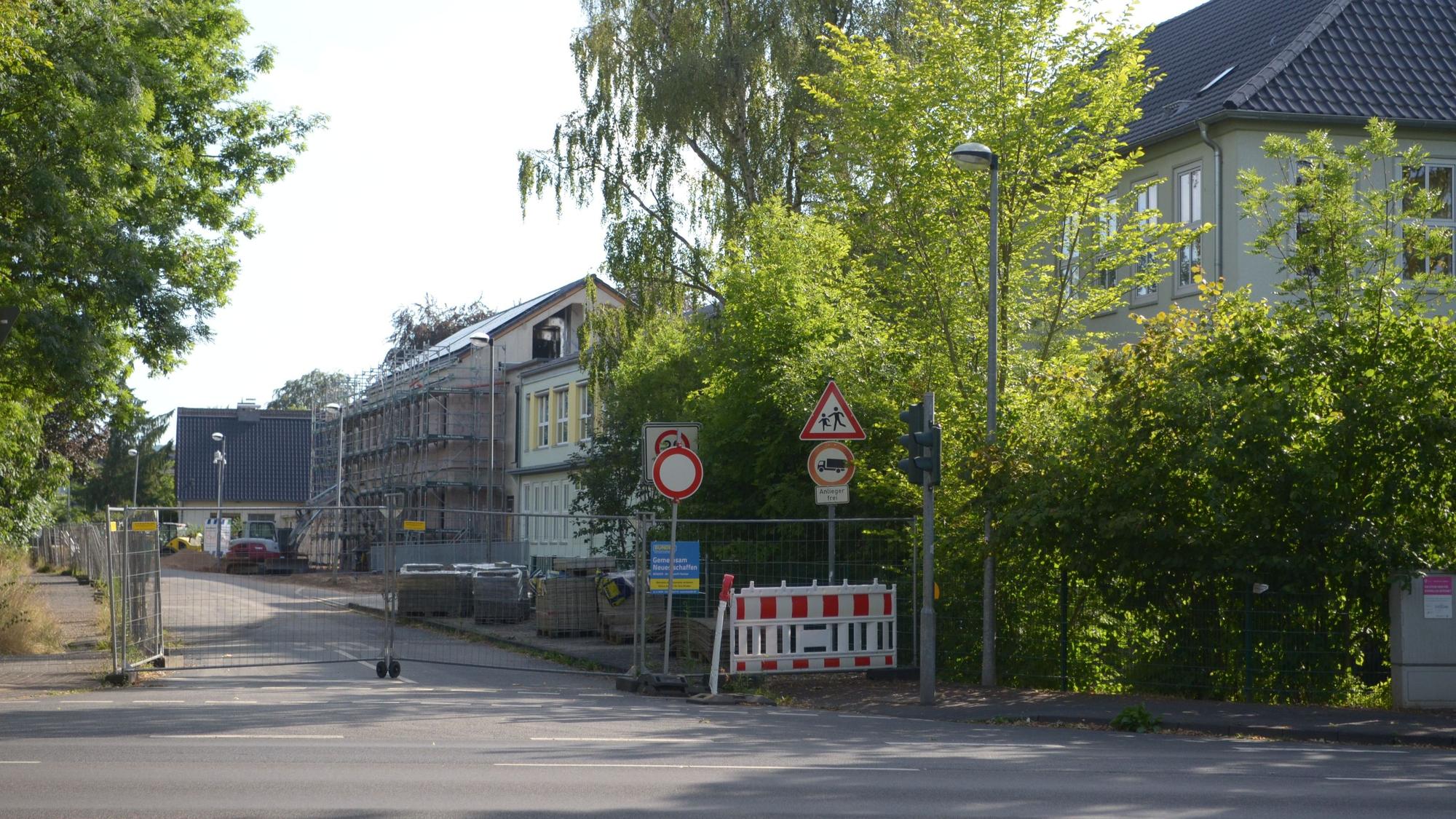 Die Straße ist mit einem Bauzaun abgesperrt. Im Hintergrund liegen die Gebäude der Franziskusschule.