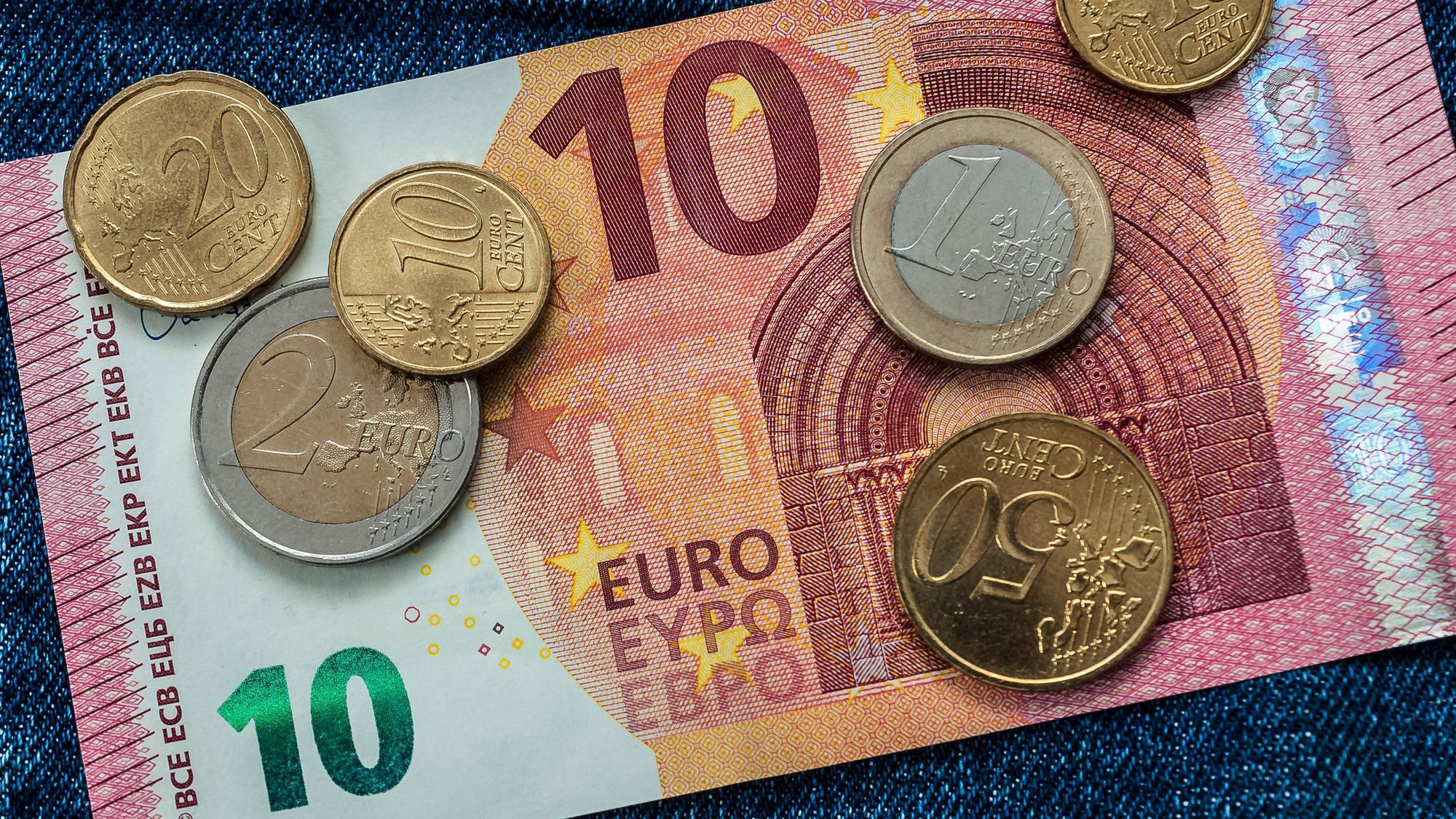 Detailaufnahme eines 10-Euro-Scheins mit Münzen (Symbolbild)