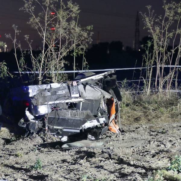 Ein Feuerwehrmann kniet neben dem Autowrack.