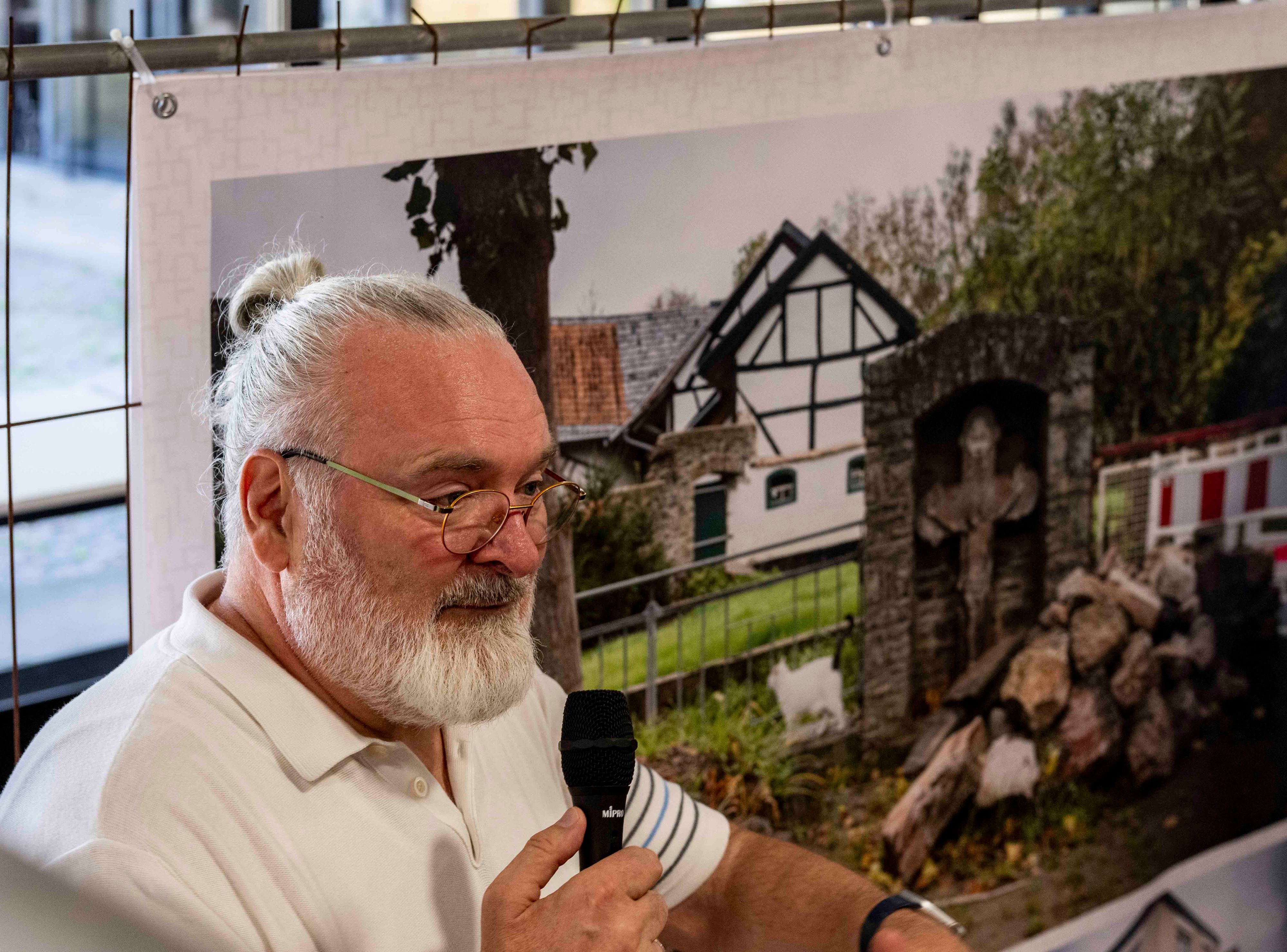 Das Bild zeigt Joachim Rieger mit einem Mikrofon in der Hand.