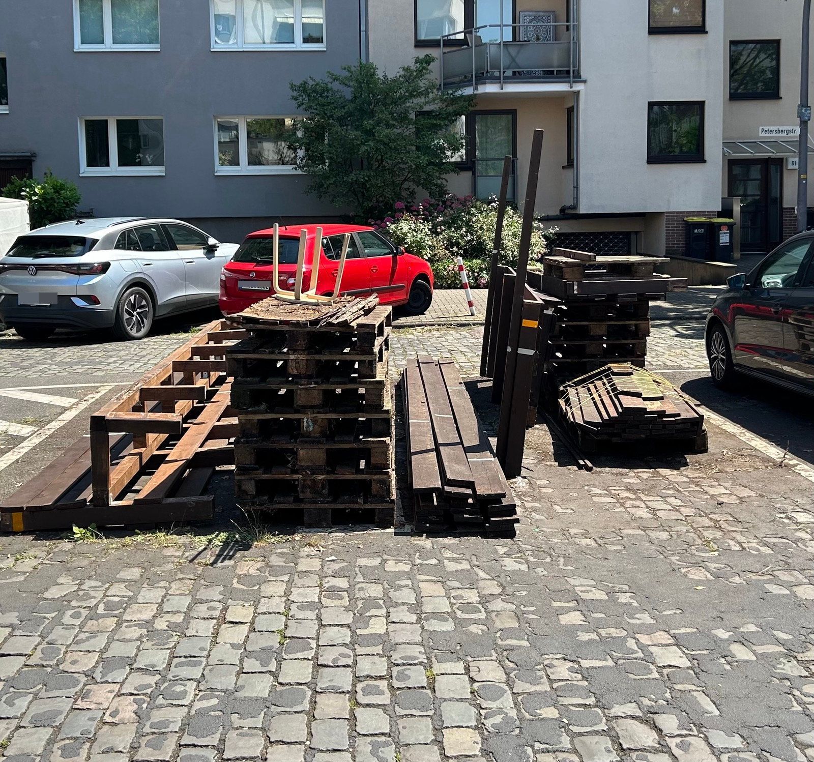 Auf einem Parkplatz stehen Holz-Elemente.